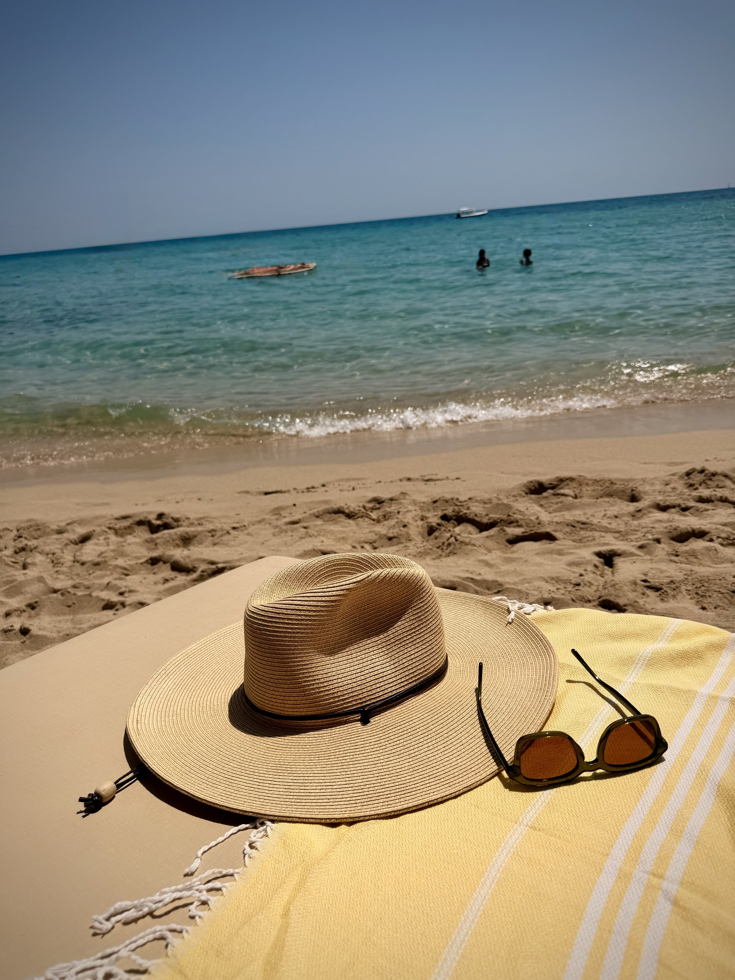 Straw hat on a sandy Puglia beach near Trullo Ostro