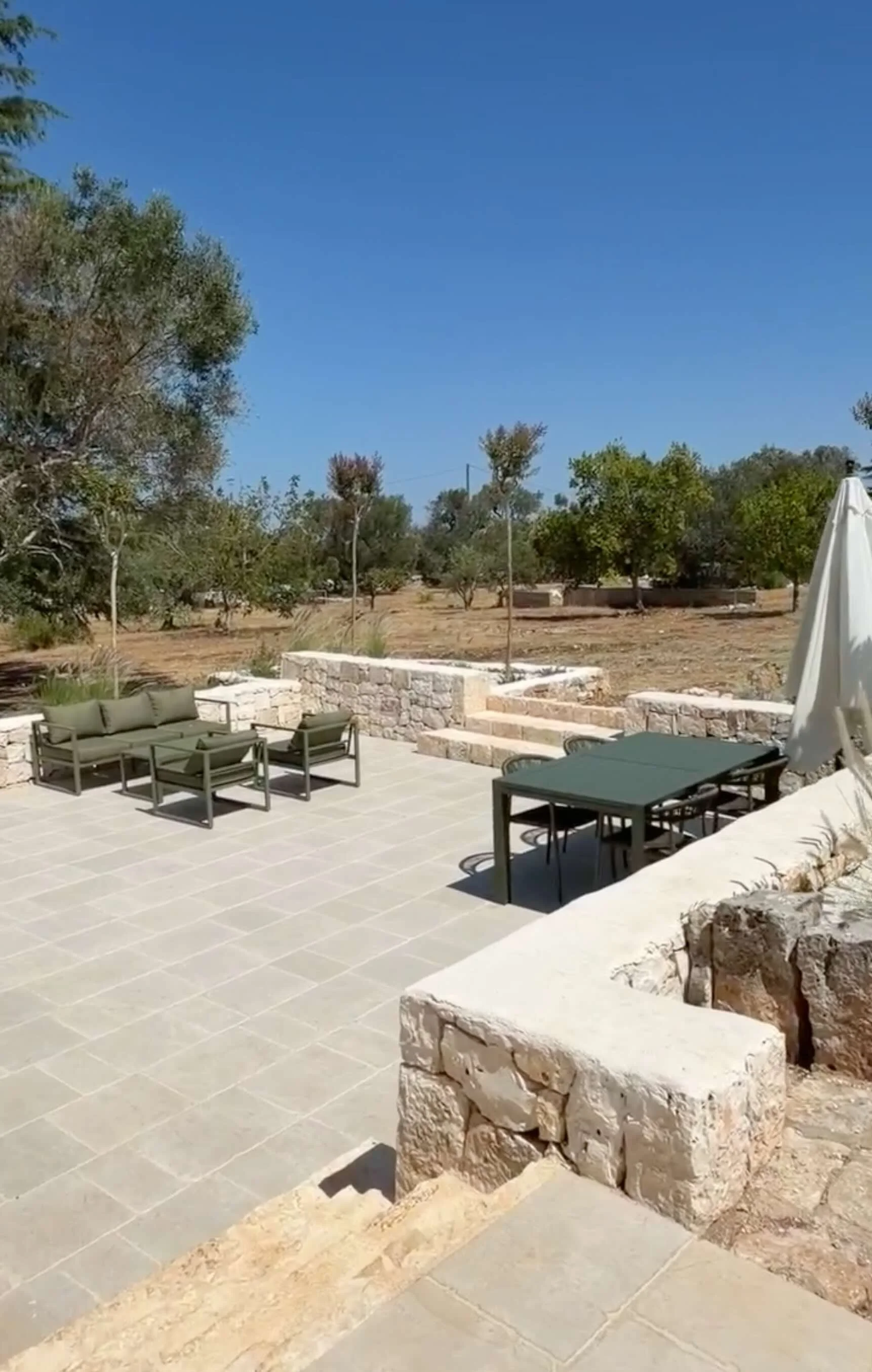 Terrace with outdoor dining and lounge furniture at Trullo Ostro