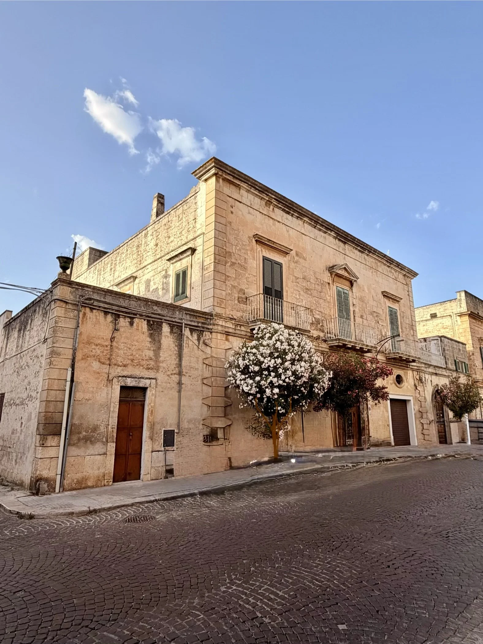 Golden stone palazzo with flowering tree in a Puglia town