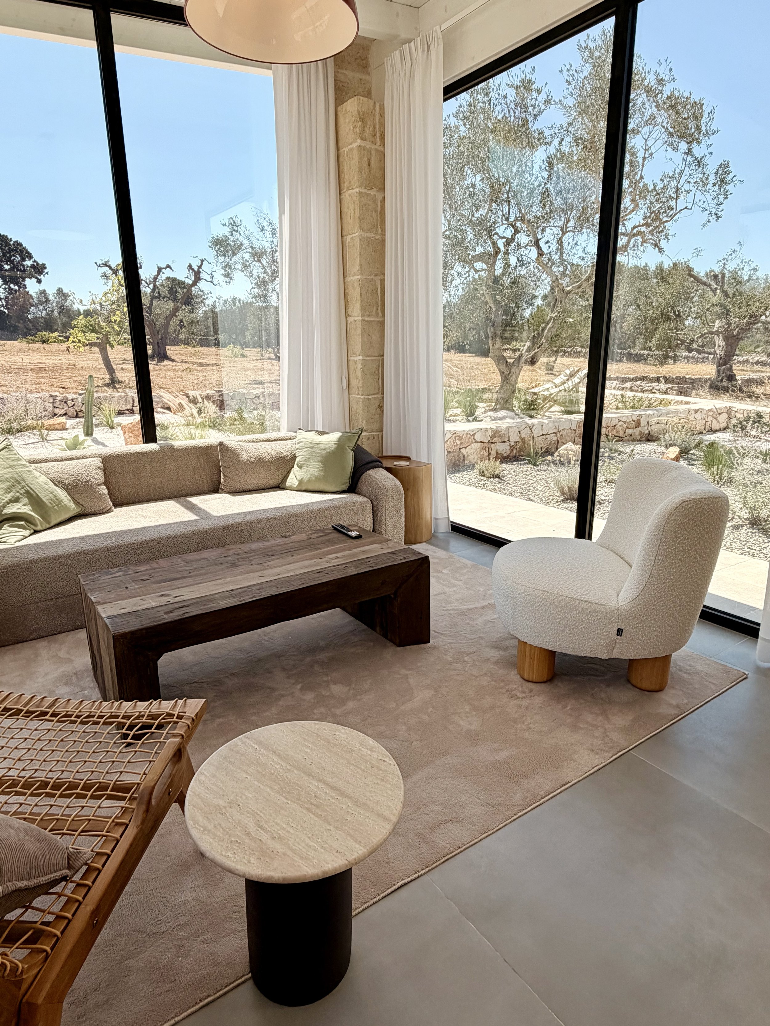 Living room with sofa and olive grove views at Trullo Ostro