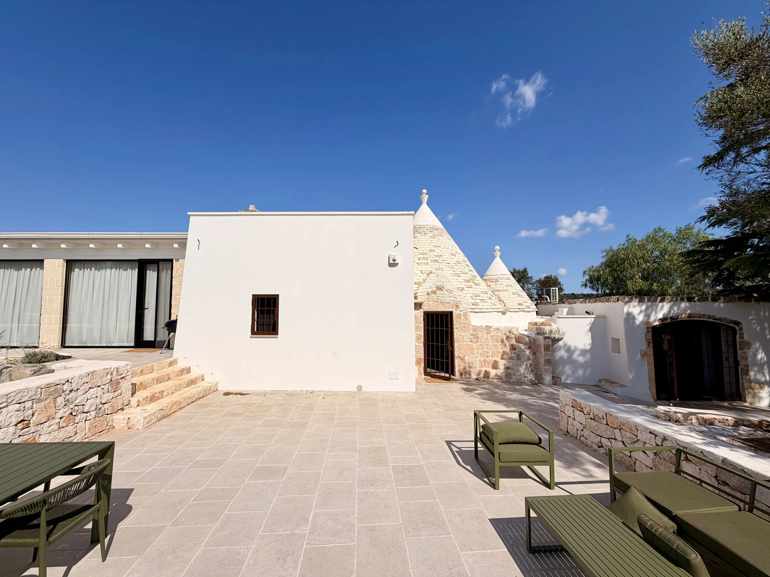 Whitewashed courtyard and trulli at Trullo Ostro, a Fable Retreats villa in Ostuni