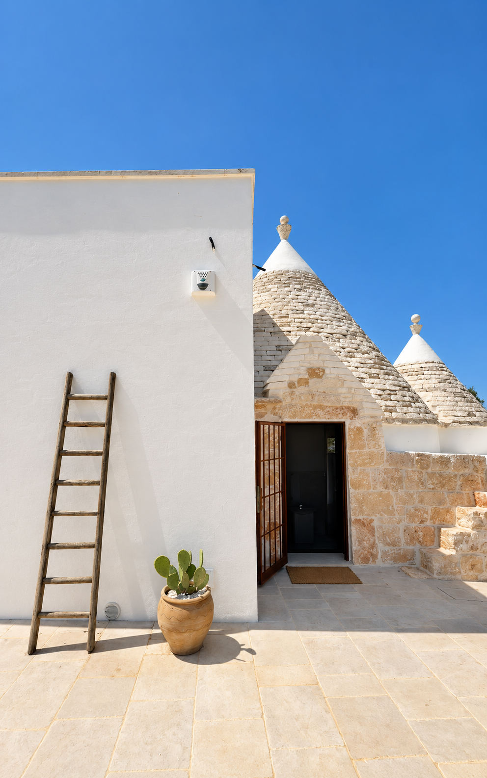 Whitewashed trullo cones and ladder at Trullo Ostro by Fable Retreats in Ostuni