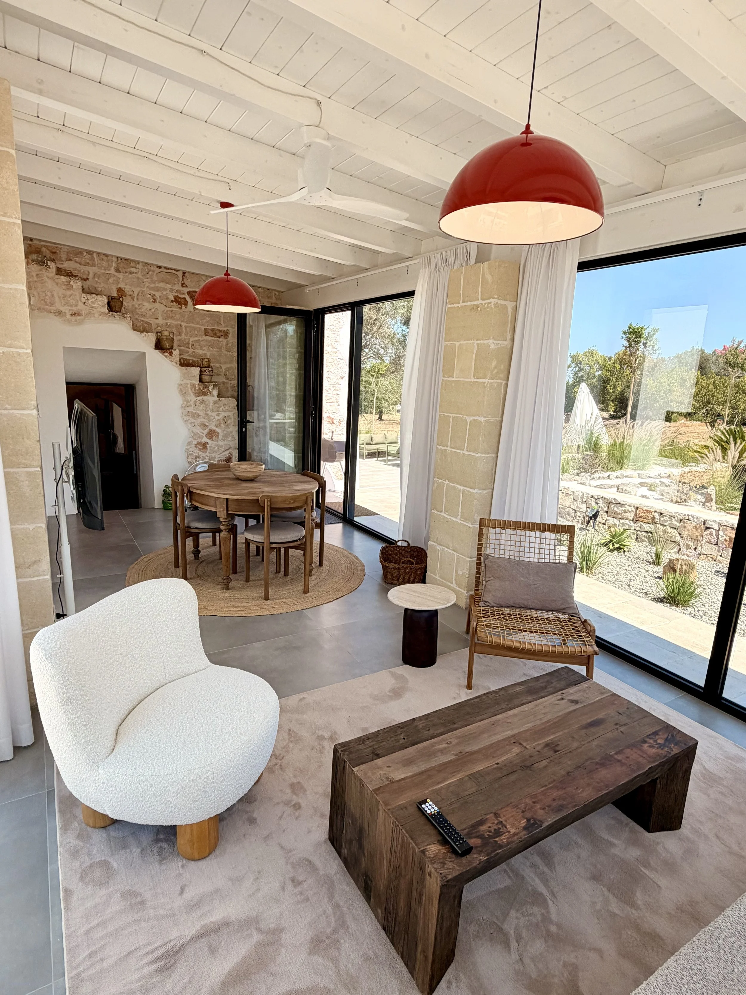 Open living and dining room under a stone arch at Trullo Ostro, Ostuni