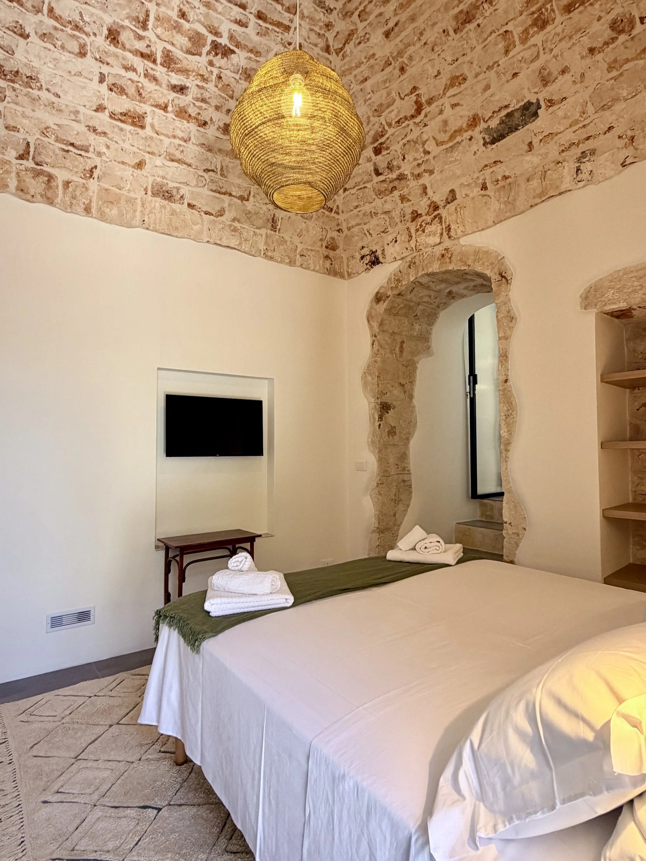Bedroom with stone archway at Trullo Ostro