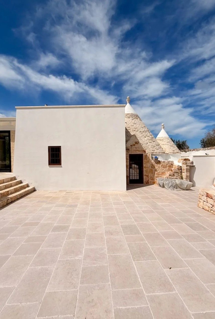 Whitewashed courtyard under a blue Puglia sky at Trullo Ostro by Fable Retreats