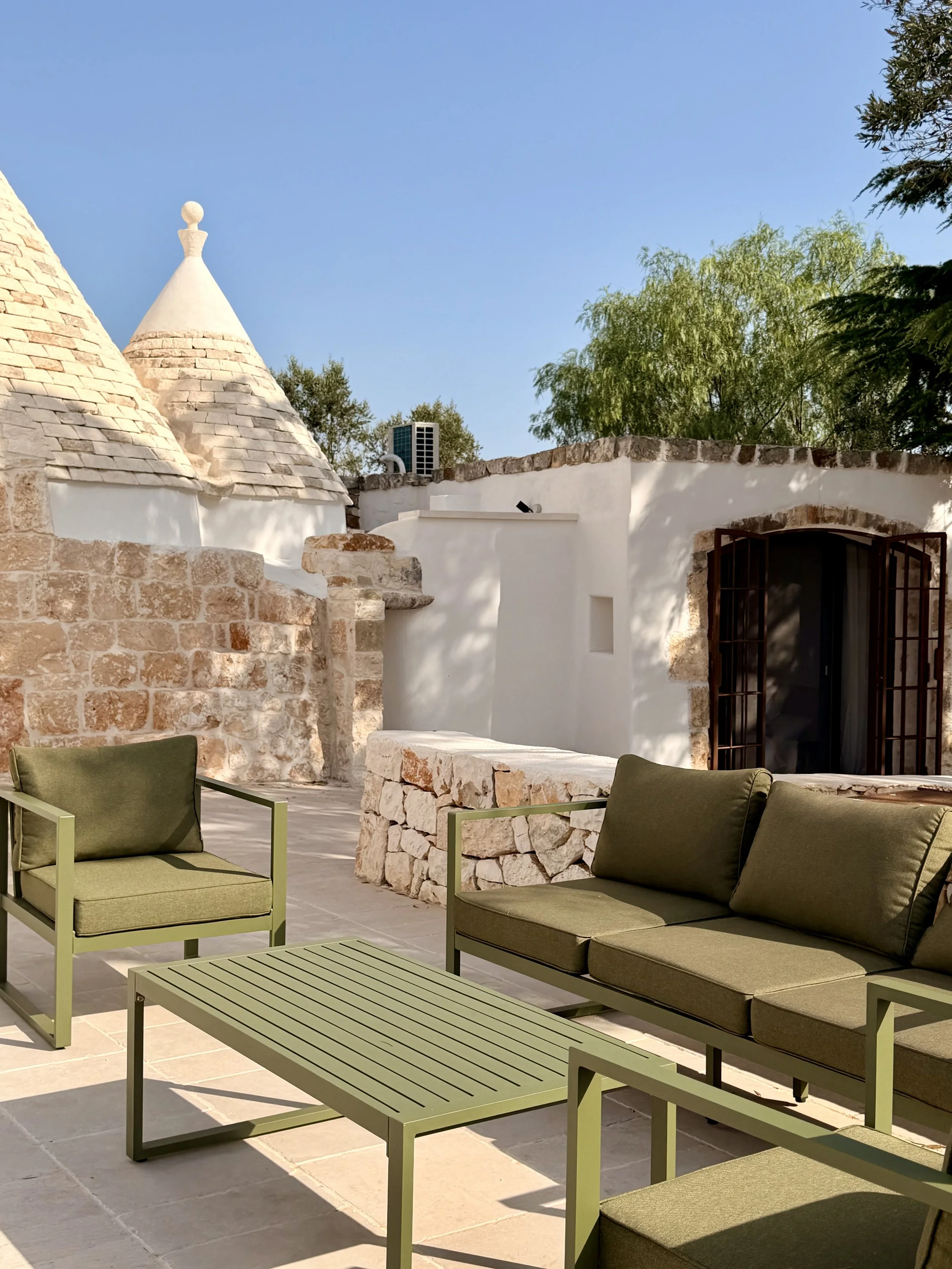 Patio seating beside the trullo at Trullo Ostro by Fable Retreats