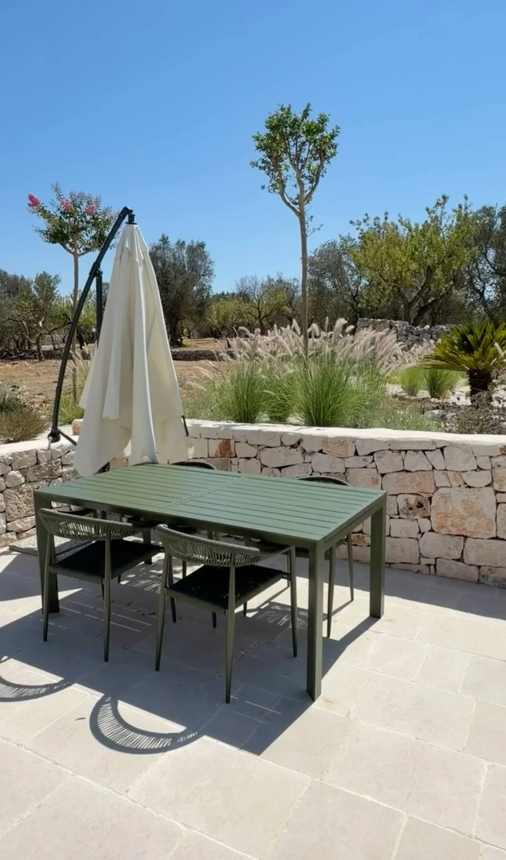 Outdoor dining table on the stone terrace at Trullo Ostro