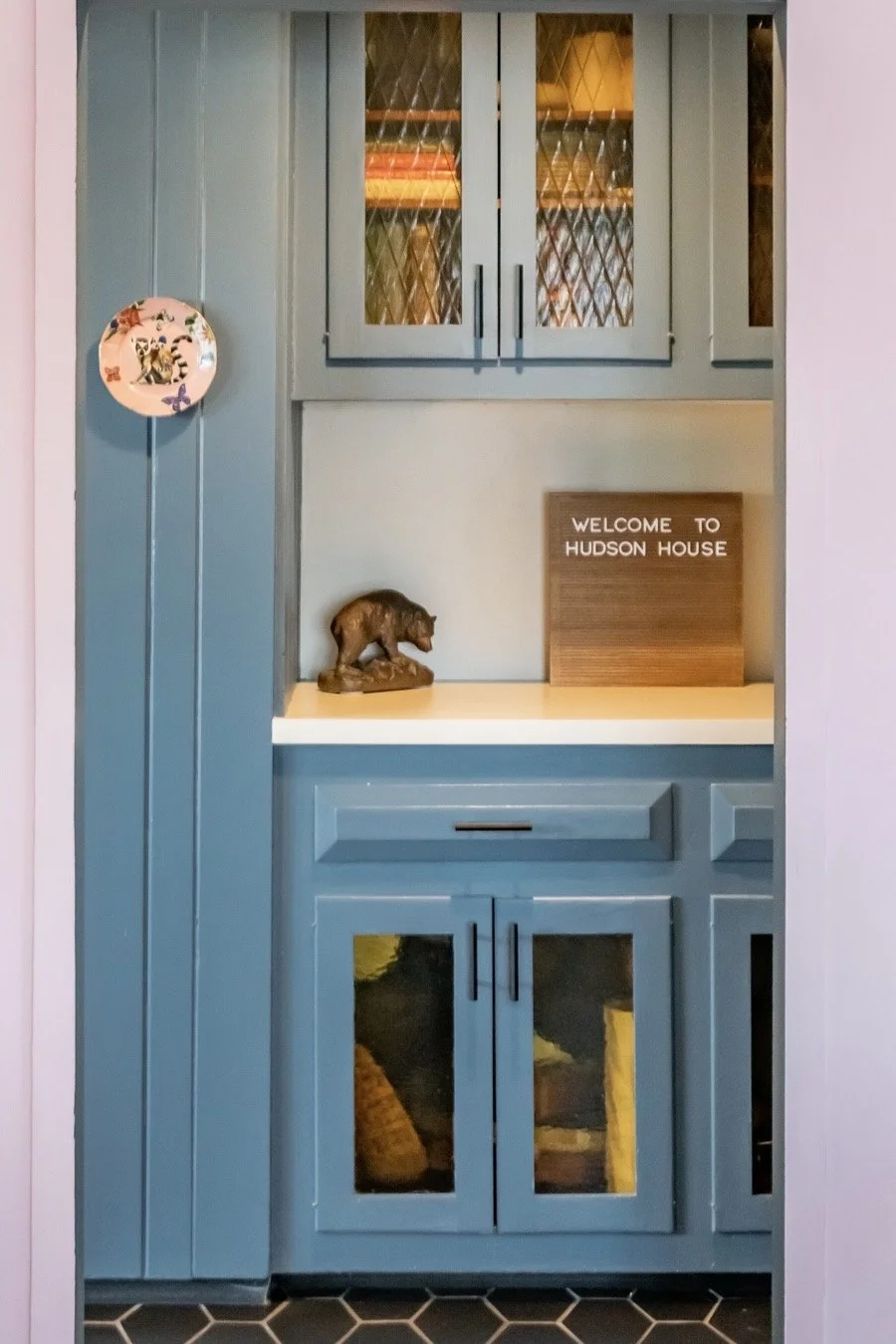 Blue built-in coffee bar with a Welcome to Hudson House sign
