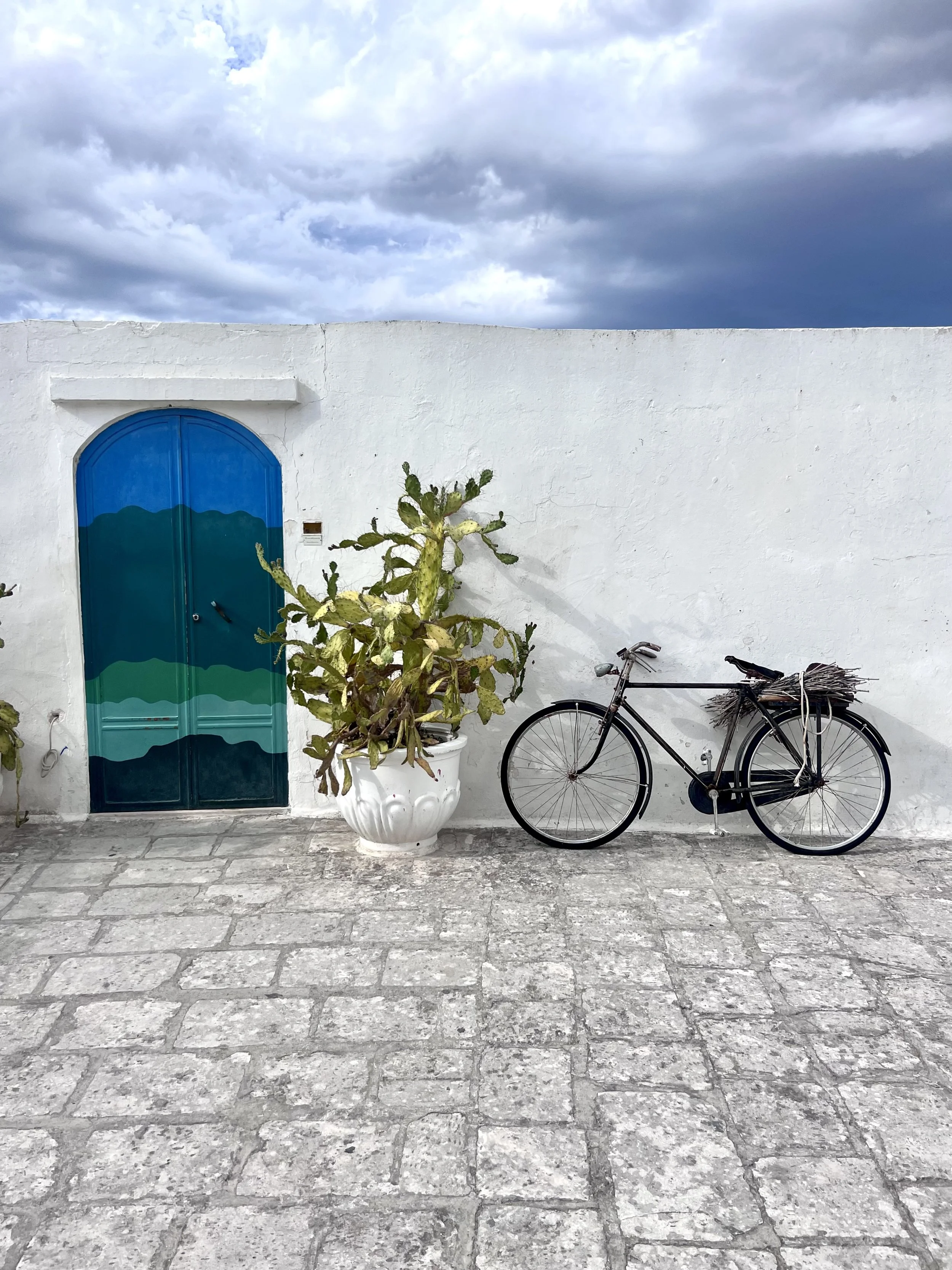Blue door and bicycle on a whitewashed Puglia street