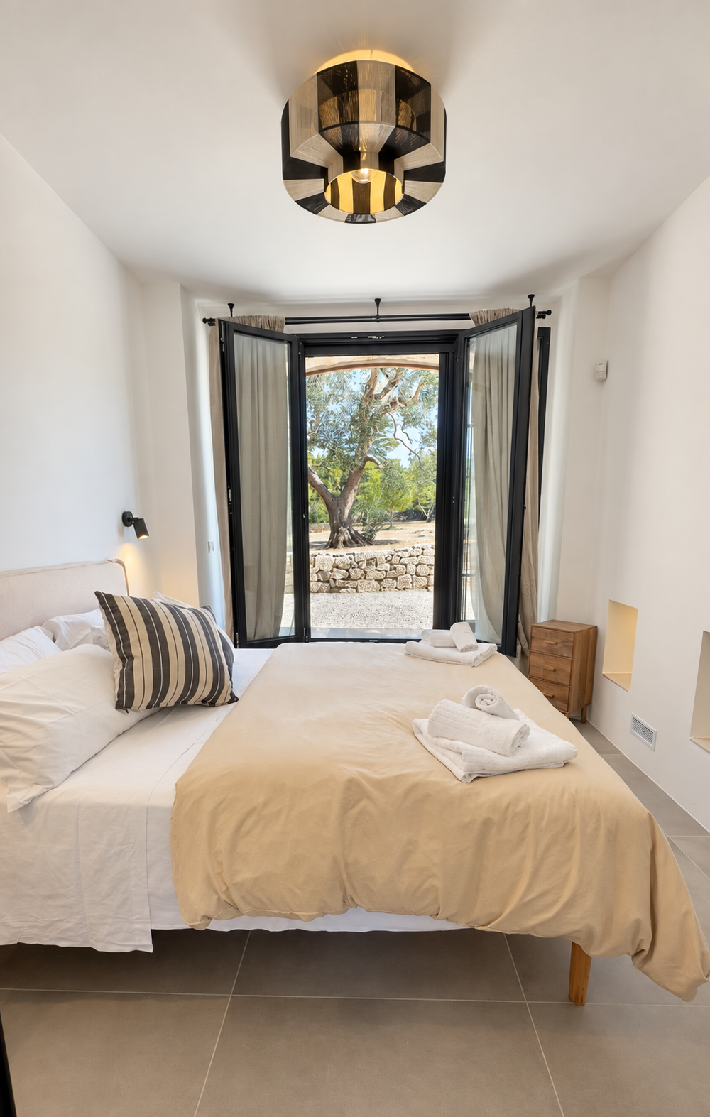 Bedroom opening onto the olive trees at Trullo Ostro, a Fable Retreats villa