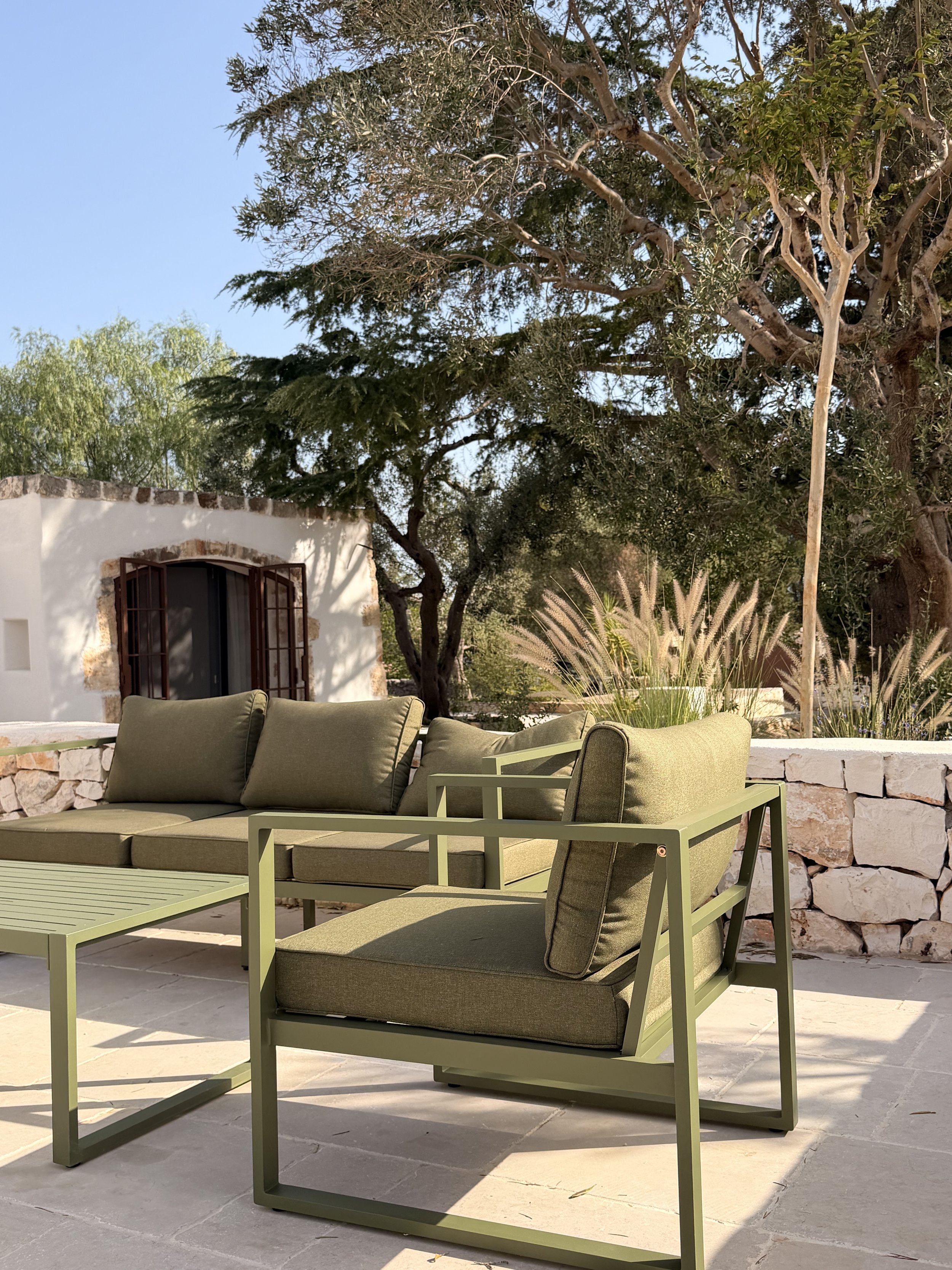 Courtyard lounge with green cushions at Trullo Ostro