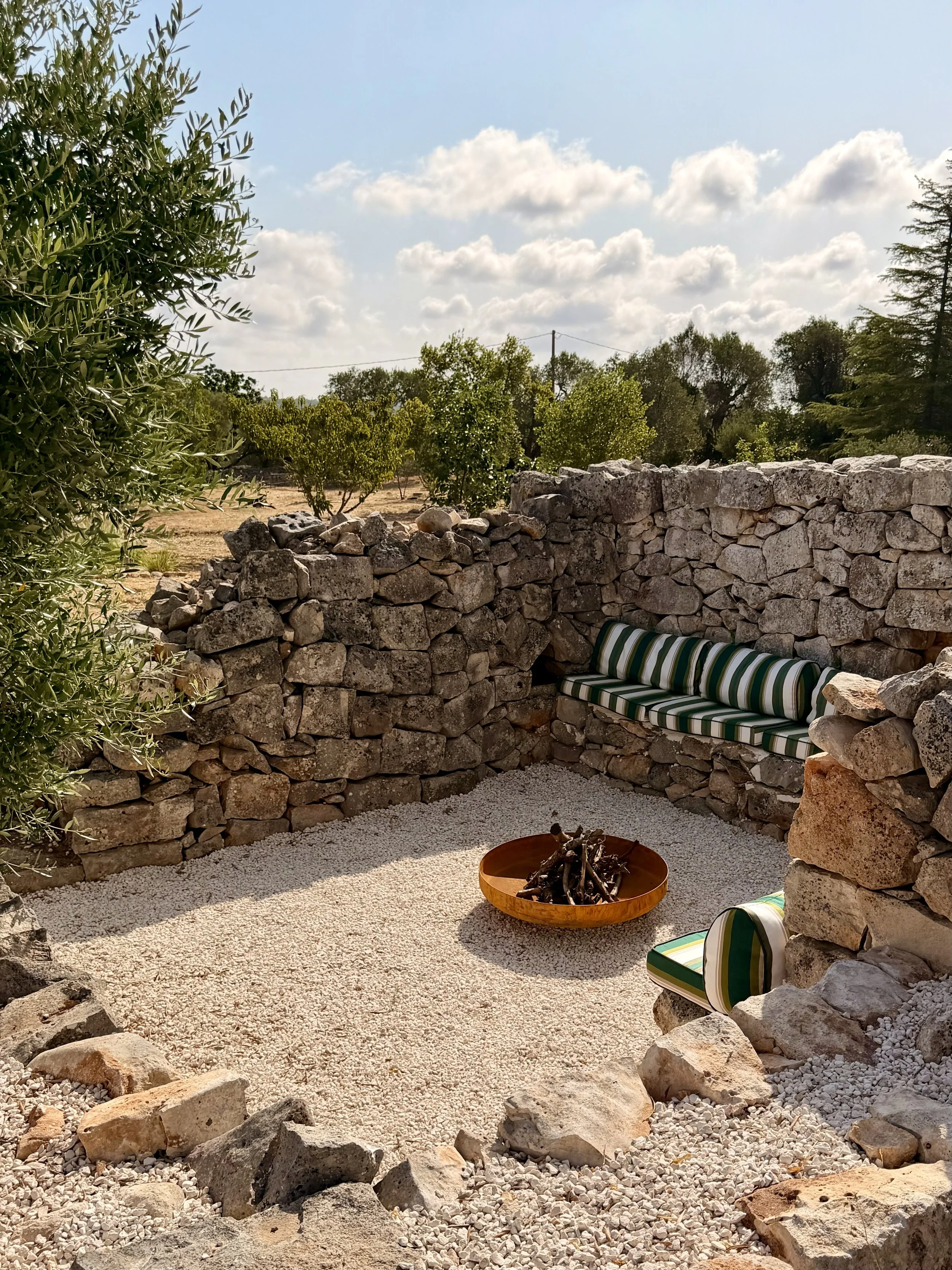 Sunken seating area and fire bowl in the garden at Trullo Ostro