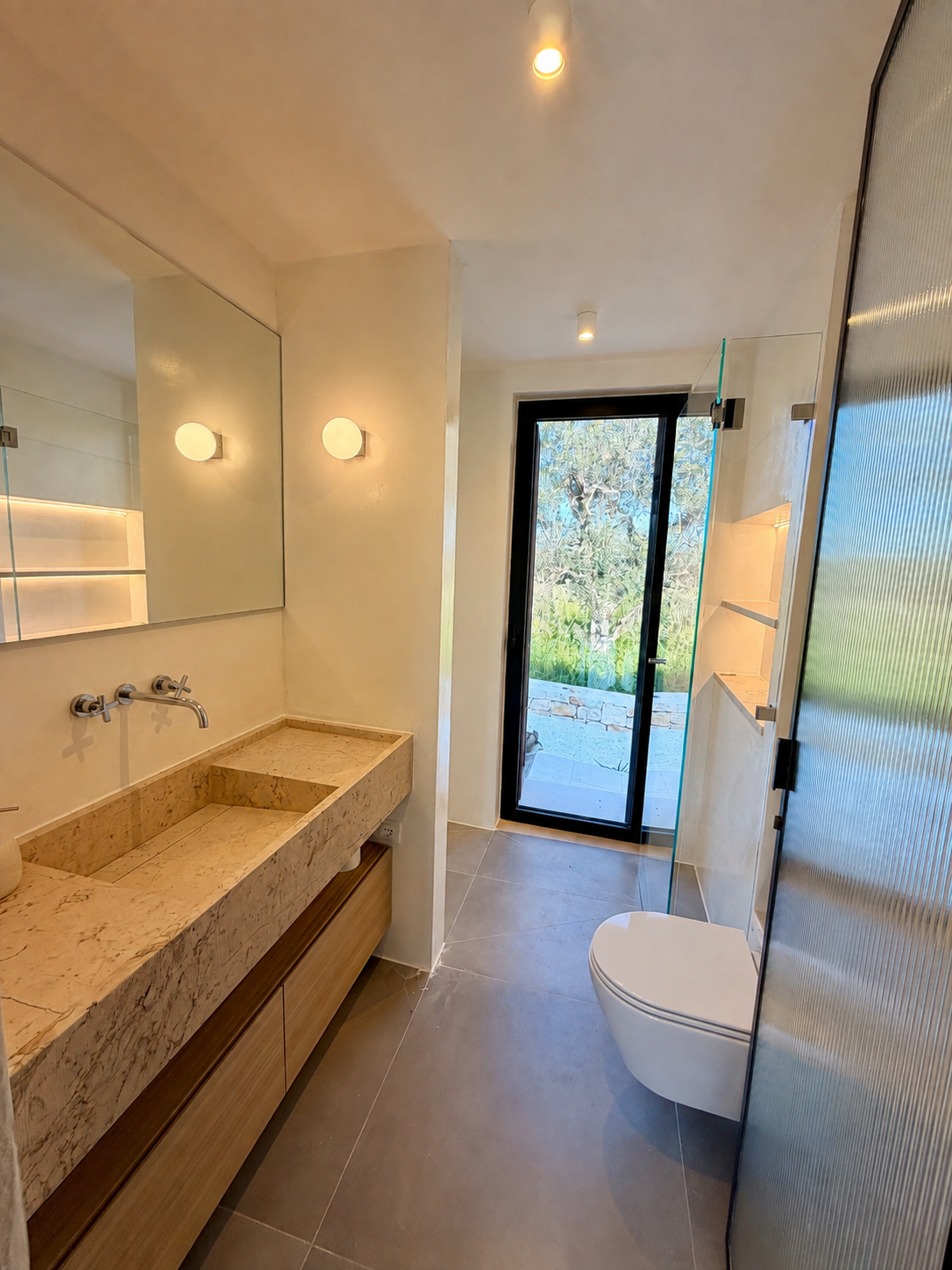 Bathroom with stone sink and garden view at Trullo Ostro