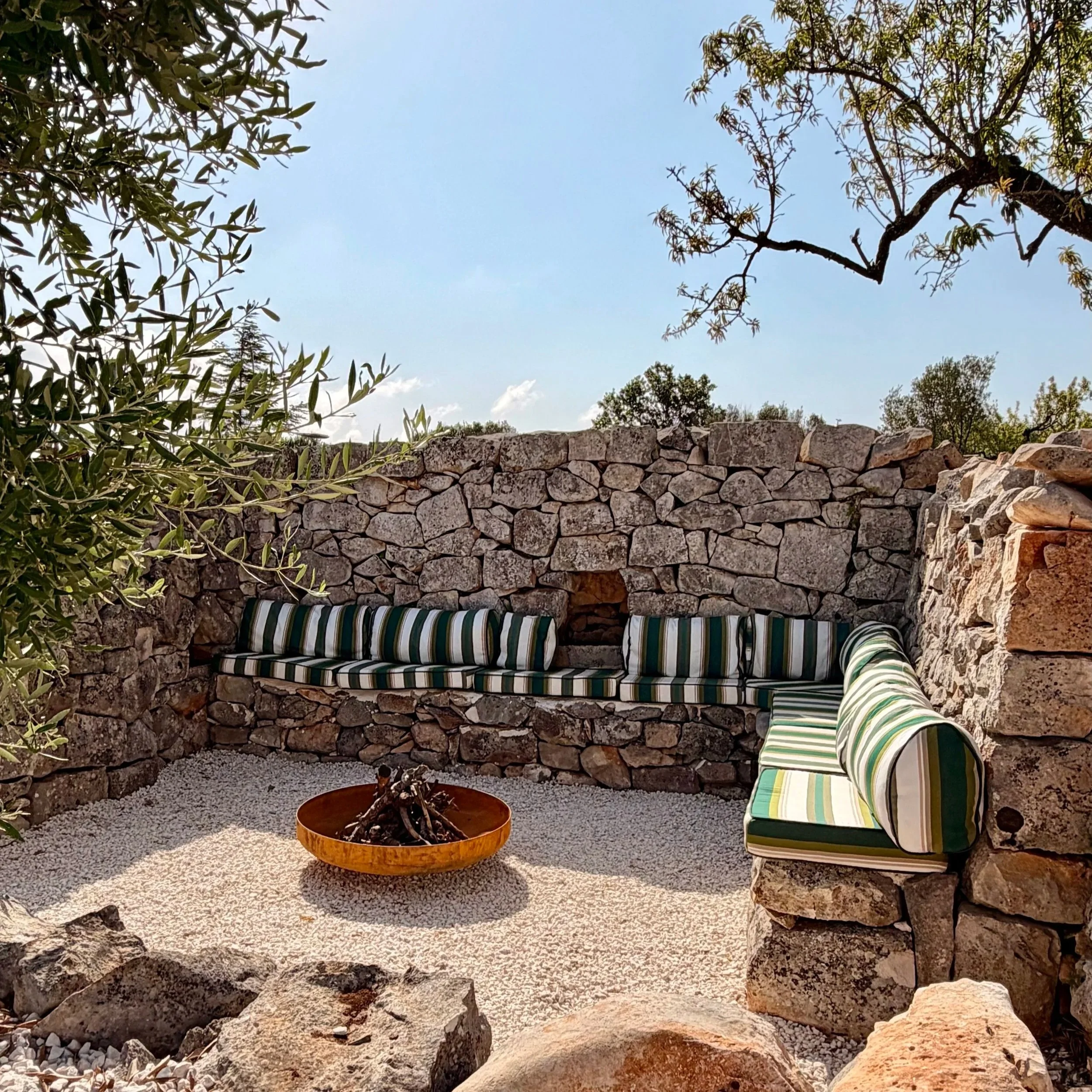 Sunken fire-pit lounge built into an ancient stone ruin at Trullo Ostro
