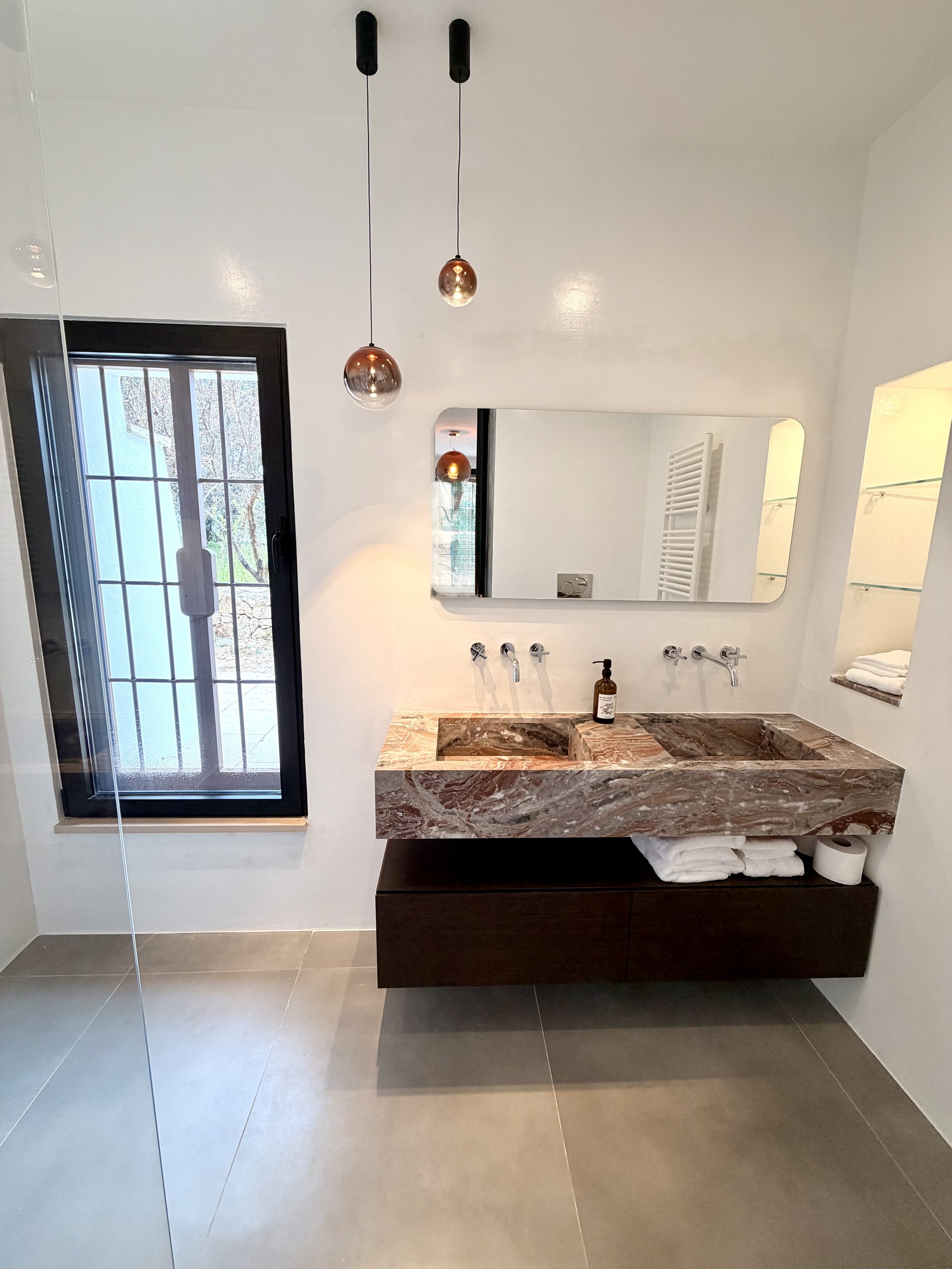 Bathroom with marble sink and arched window at Trullo Ostro