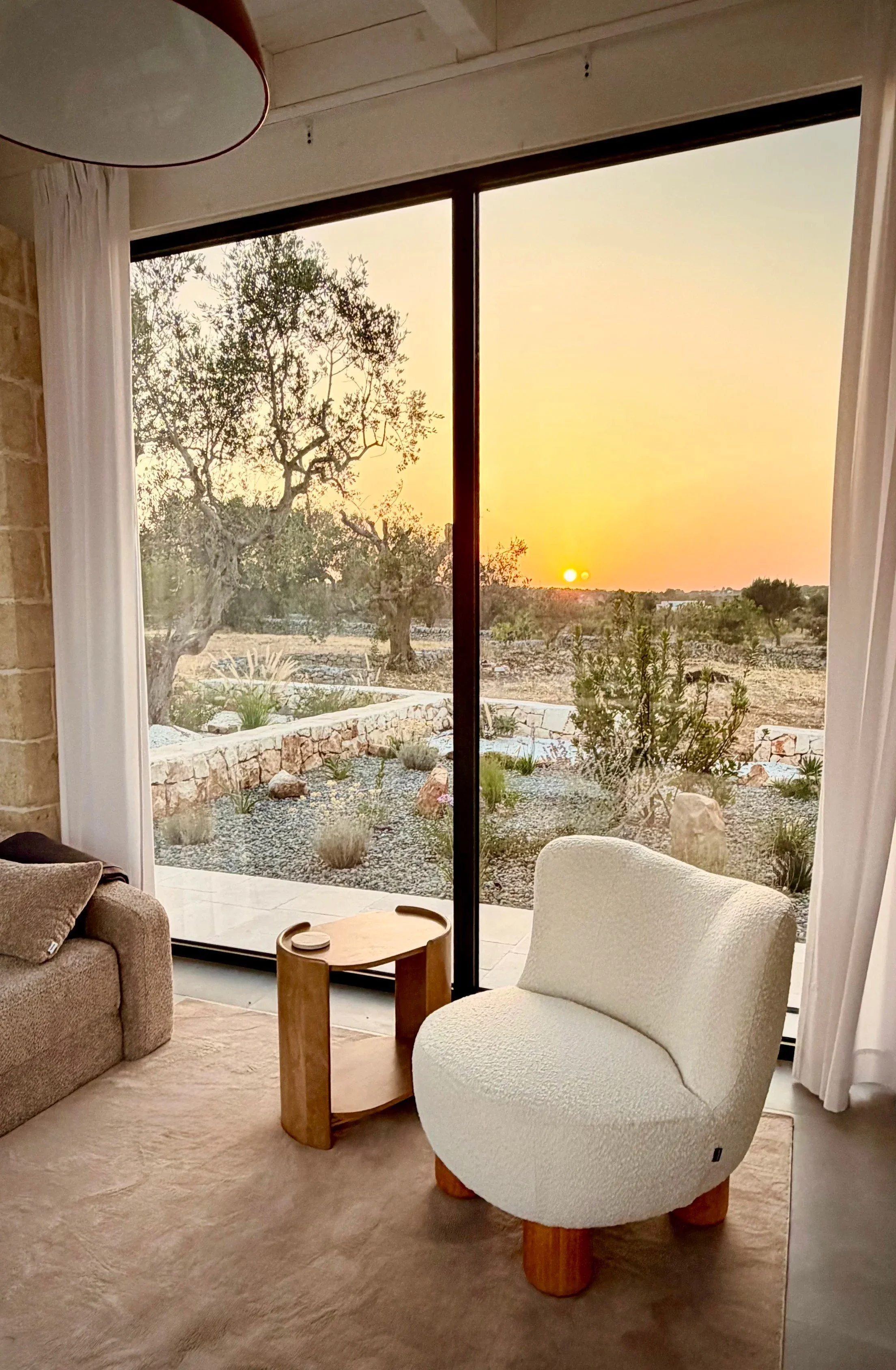 Sunset over the olive grove from the living room at Trullo Ostro by Fable Retreats
