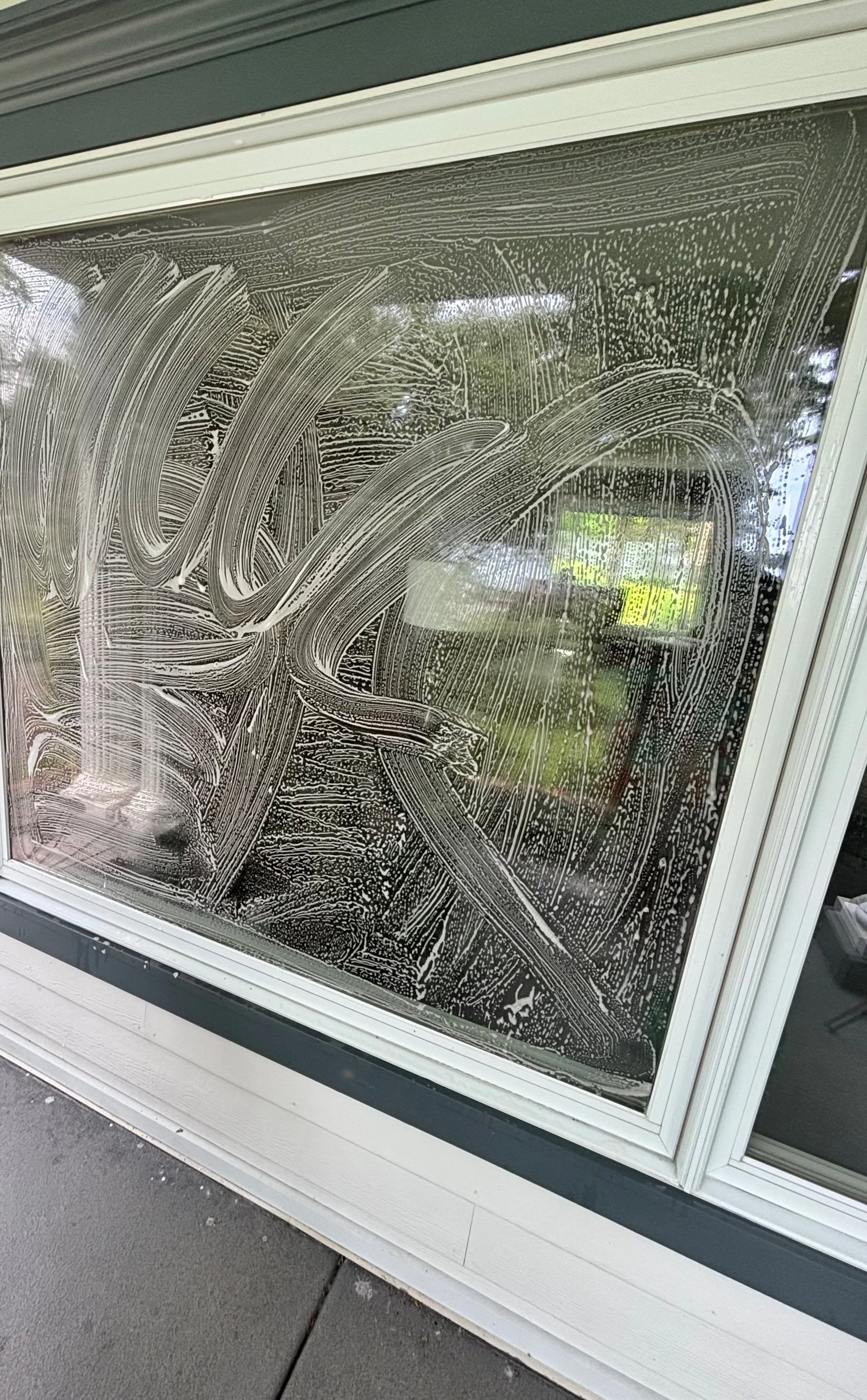 A window with dry soap or cleaning foam art.