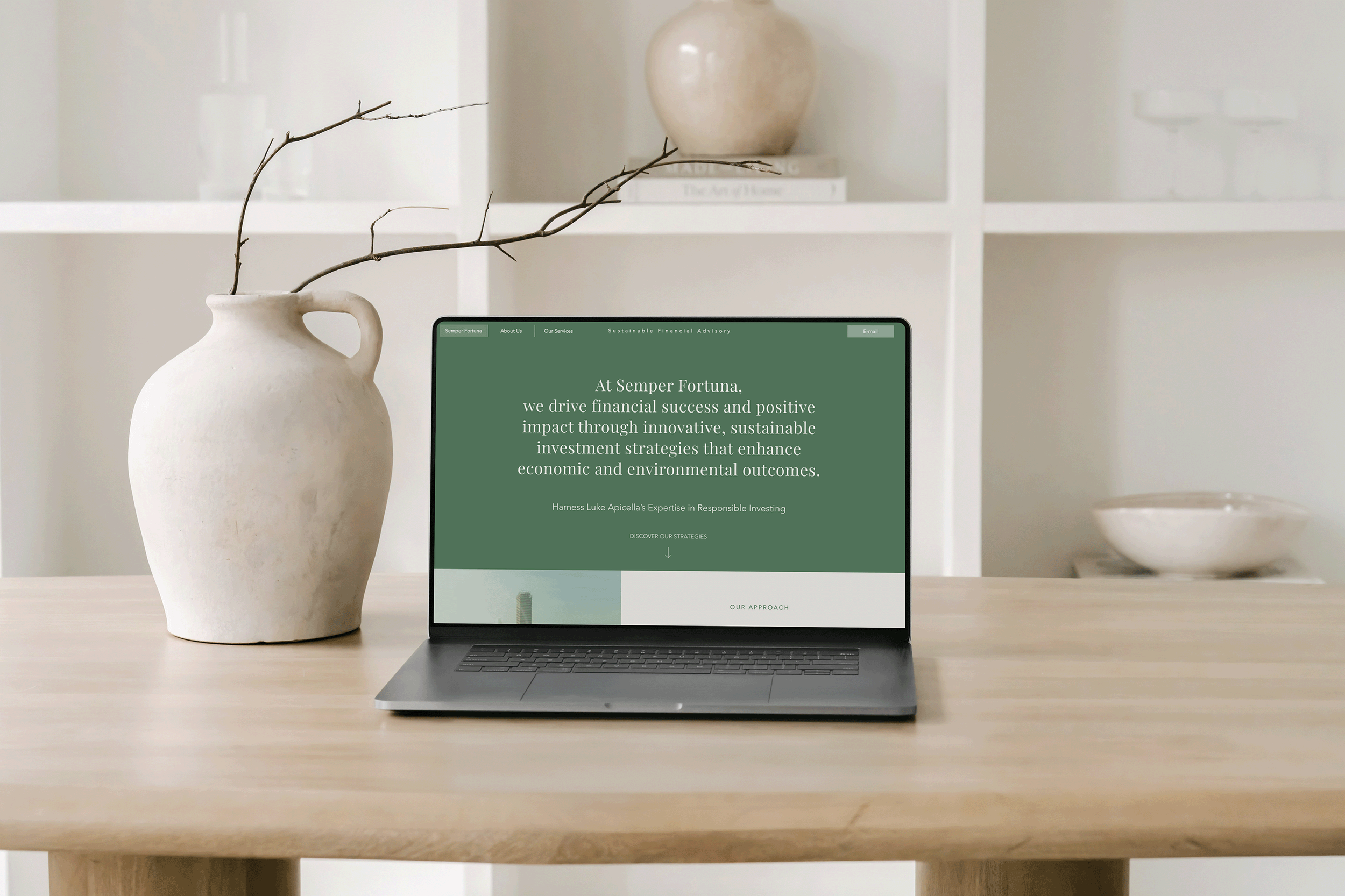 Laptop on a wooden table displaying a website for Semper Fortuna, with white ceramic vases and shelves in the background.