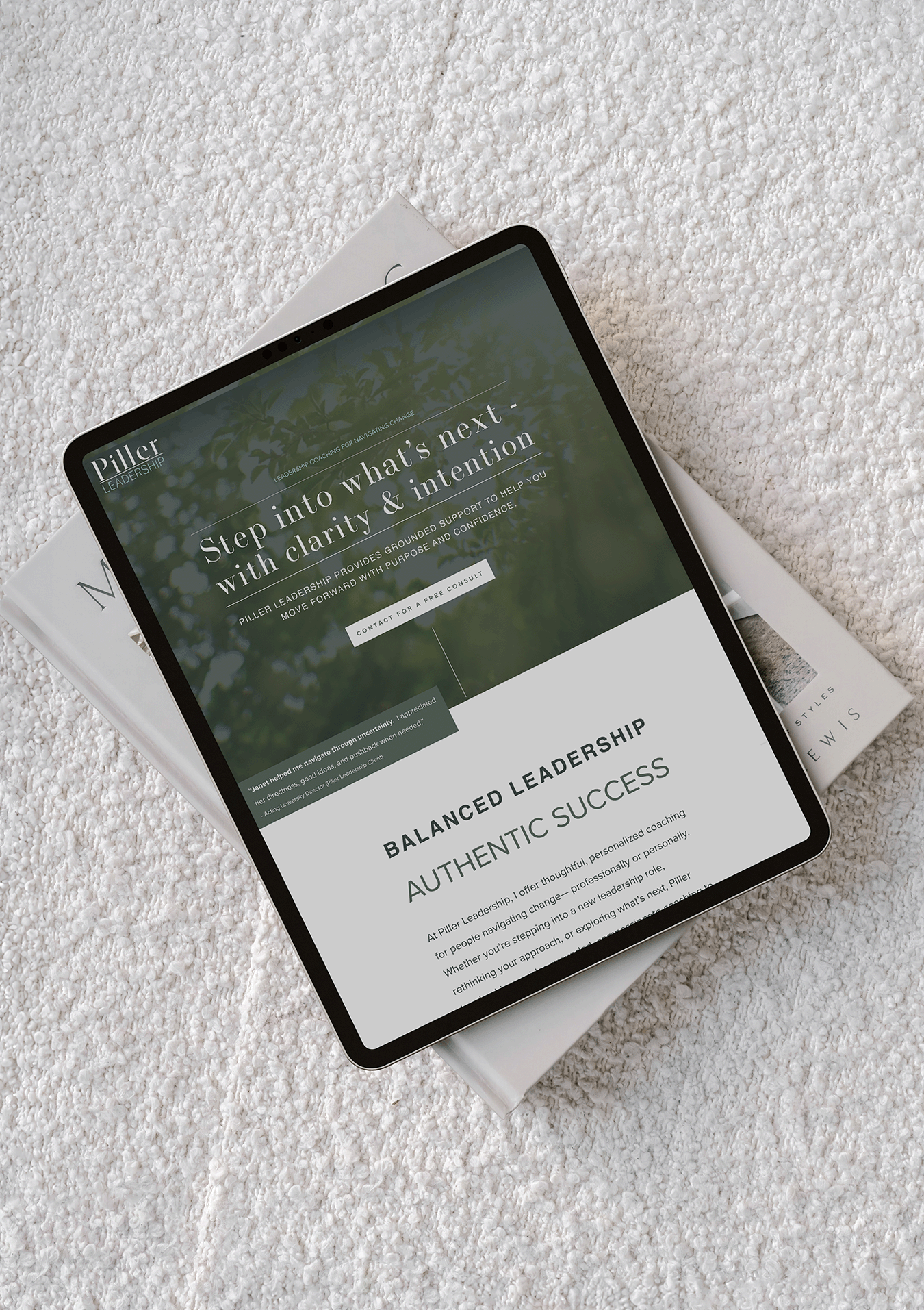 An iPad displaying a website about leadership on a white textured surface with a magazine underneath.