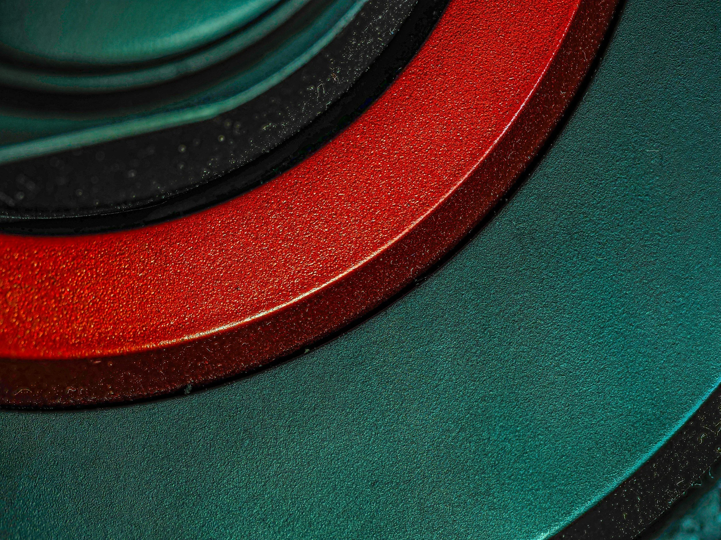 Close-up of a speaker with a red and green textured surface.