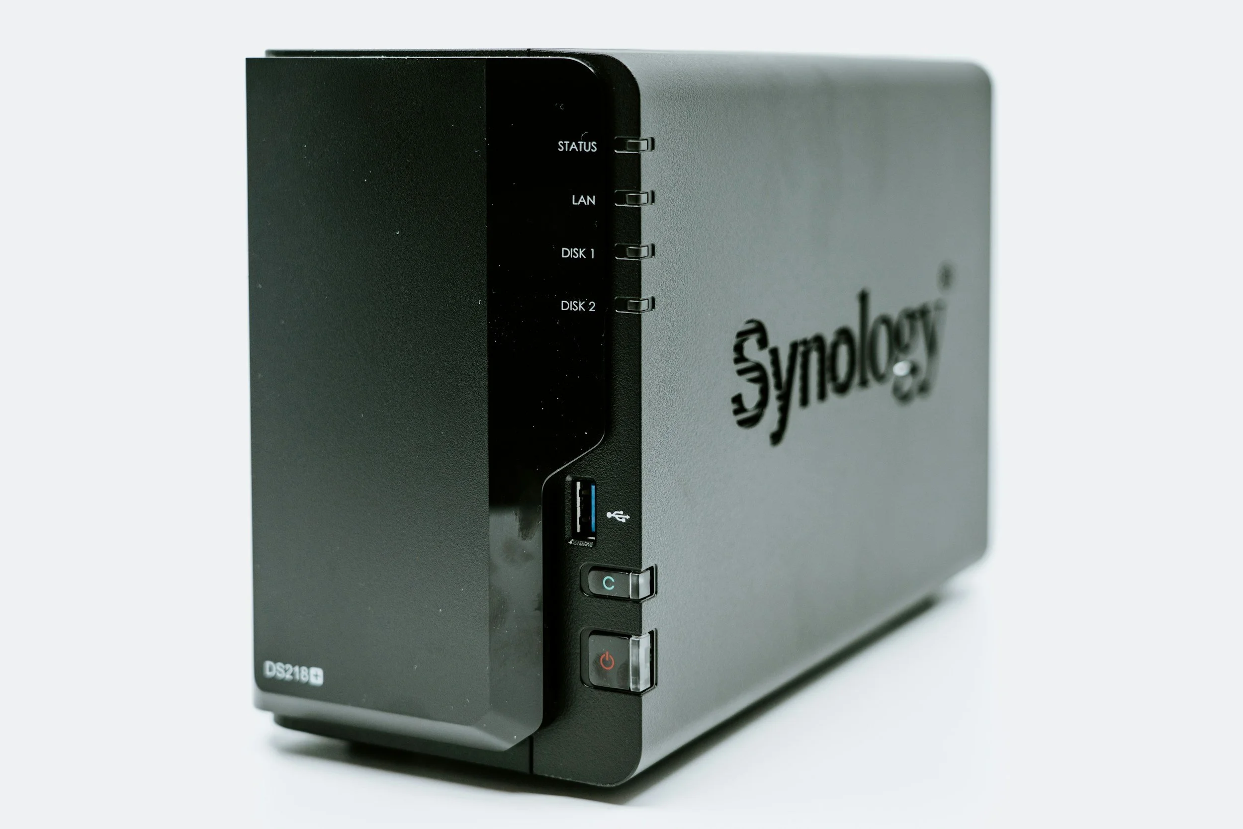 Synology network-attached storage (NAS) device with front panel displaying status lights, USB port, and power button.