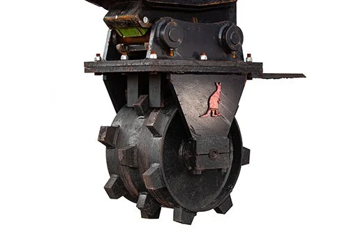 Close-up of a large industrial machine wheel or drum with a small pink dog illustration on it.