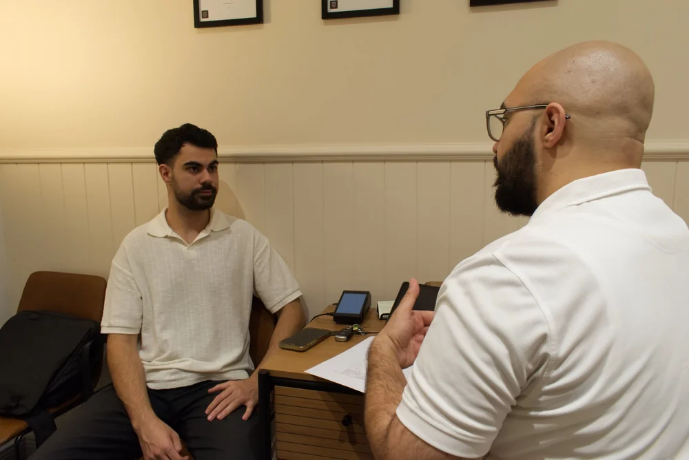 Dr Silver Esho explaining a patient's assessment findings at Spirit Chiropractic, Parramatta