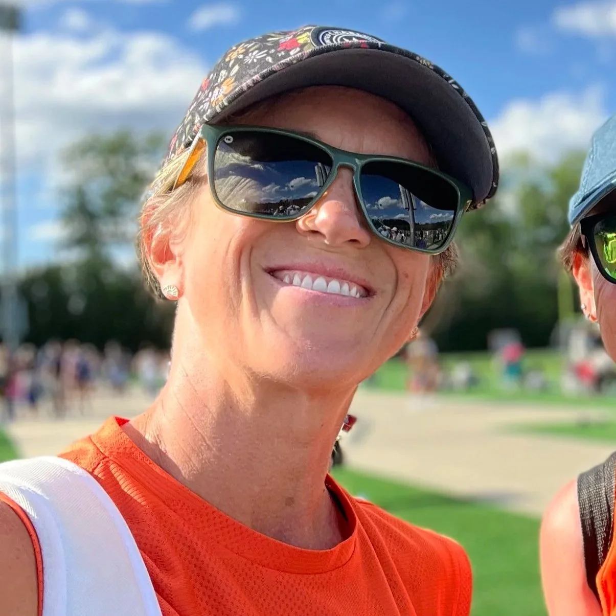 Mavericks Football Club logo with black, white, and orange colors, featuring a flower in the center and three stars above.