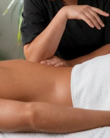 Close-up of a massage therapist performing deep tissue massage, using a forearm and elbow on the client's back.