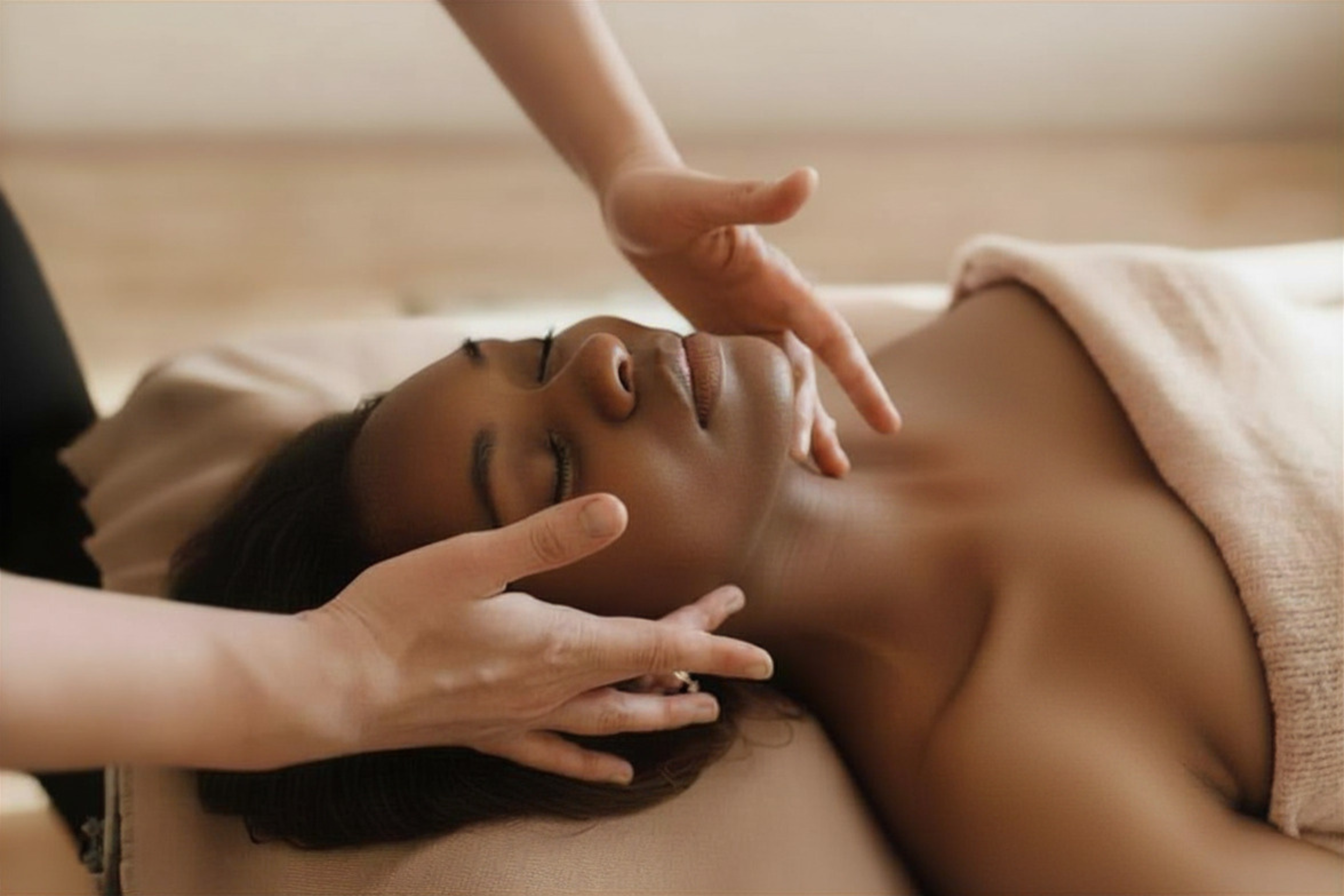 Close-up of a massage therapist performing a soothing facial massage with steam towel.