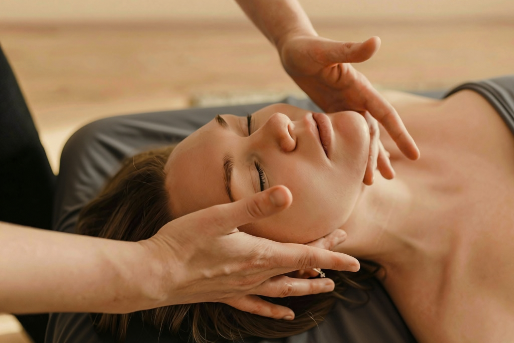 Close-up of a massage therapist performing a soothing facial massage with steam towel.