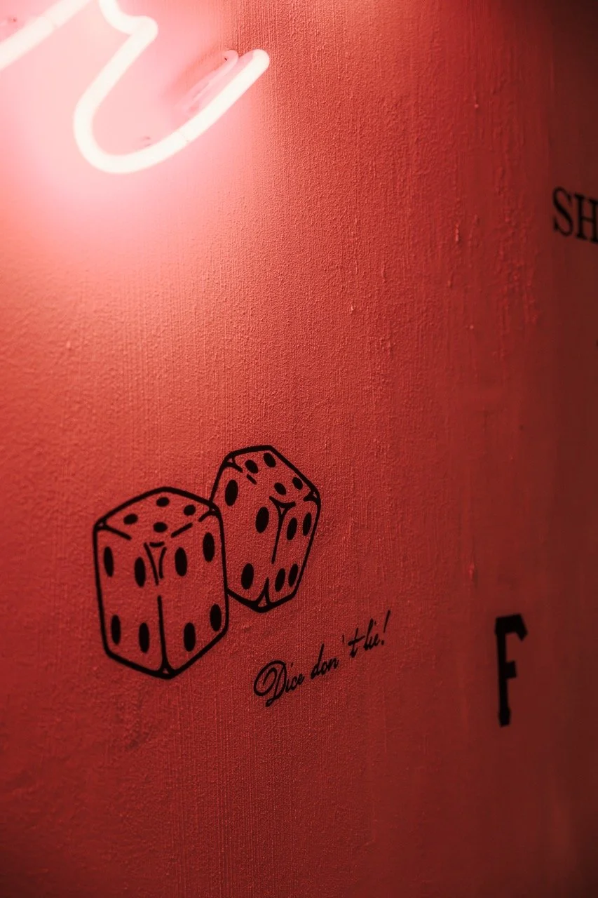 Red wall with black dice graphic and the phrase 'Dice don’t lie!'