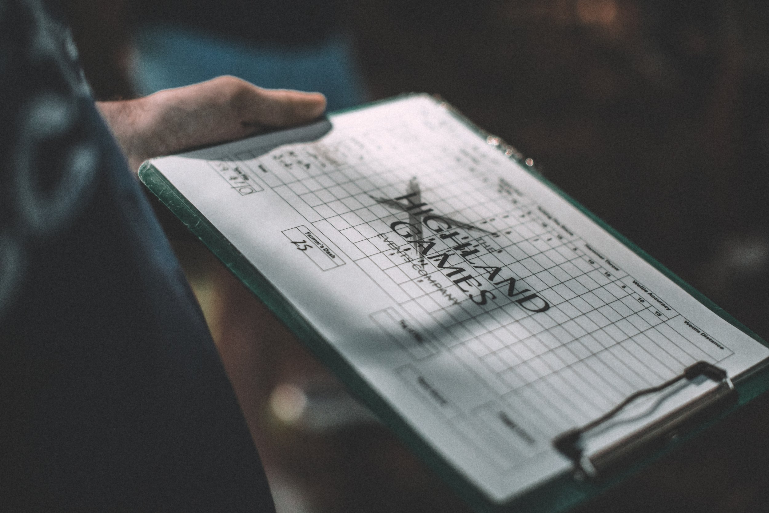 Close-up of a person holding a golf scorecard with handwritten scores and the title 'Golf Handicap' on the top.