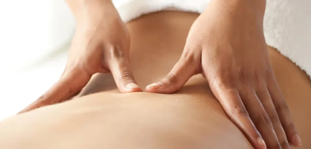 Close-up of a person receiving a massage on their back.