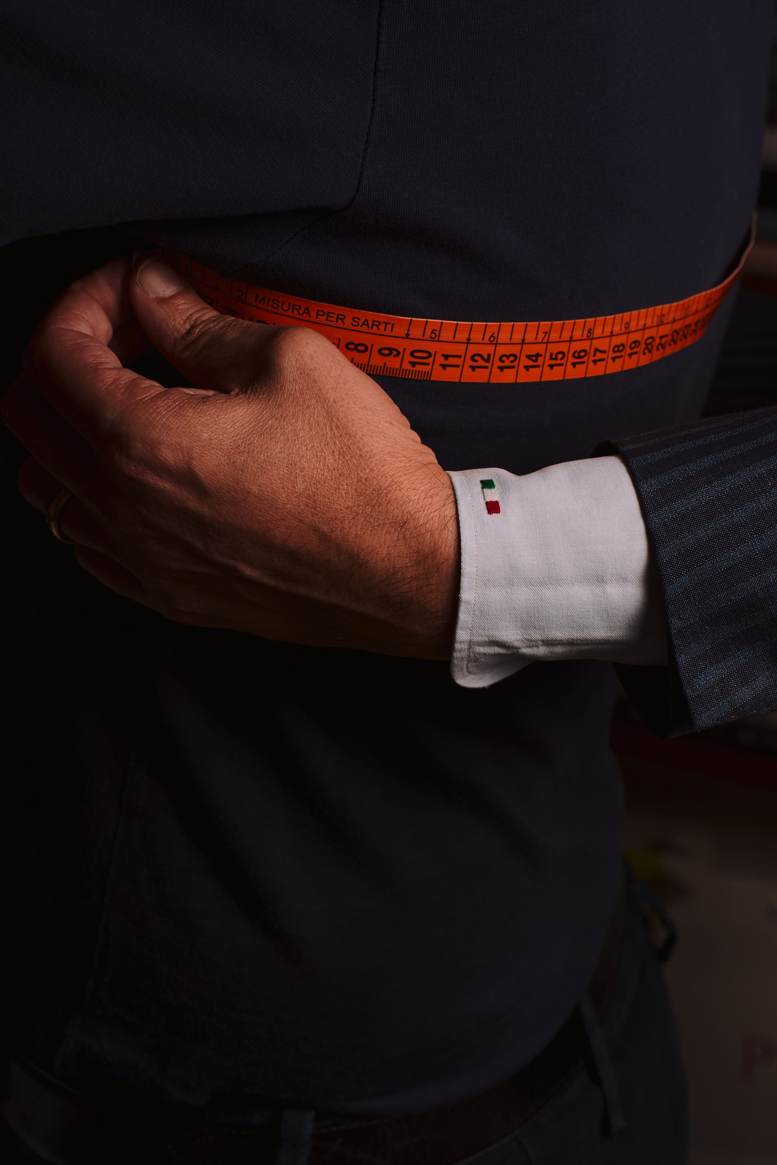 misurazioni al fianco per creare una camicia sartoriale effettuate su un cliente e che mostra il processo bespoke