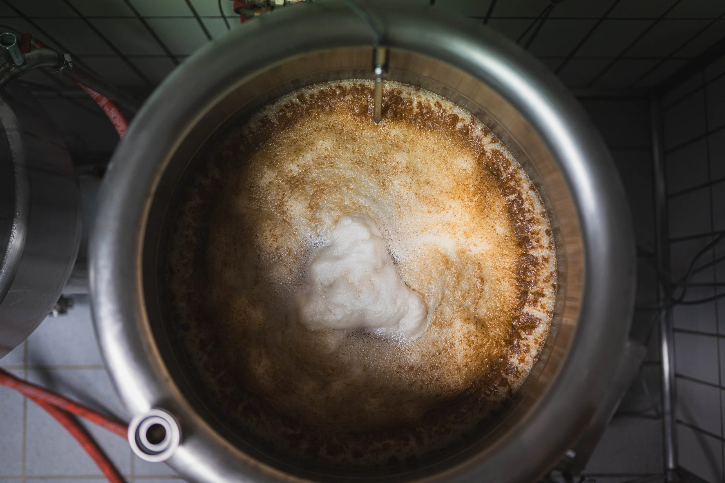 Ein Blick in eine Brauerei-Brau си der mit schaumigem Bier beim Brauprozess