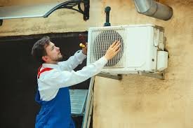 A man cleaning an outdoor air conditioning unit