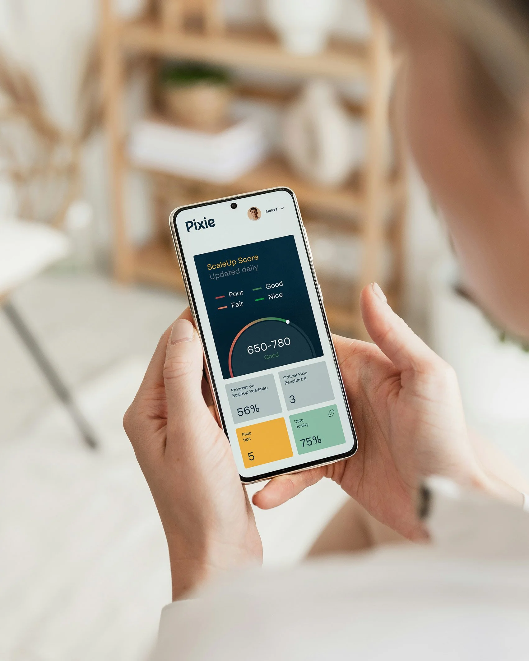 Person holding a smartphone displaying a health tracking app with score, progress, and data quality indicators.