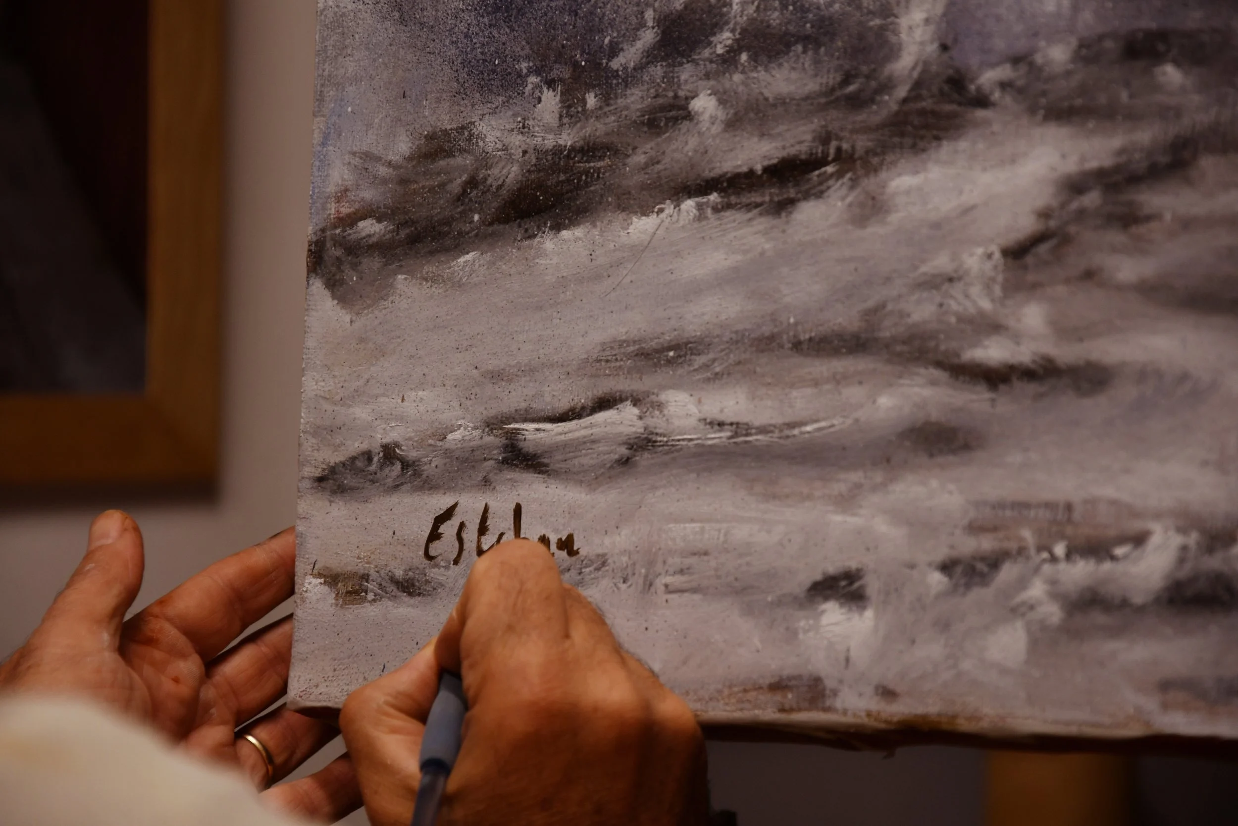 L'artiste peintre Esteban Martorell en train de signer une de ses toiles dans son atelier.