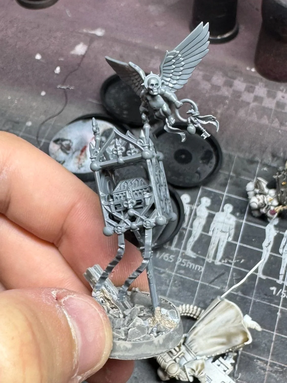 Miniature de figurine de style gothique, représentant une créature ailée avec un crâne et une arme, en cours de peinture, cherubins conversion.