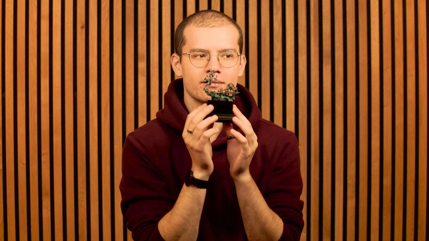 Julien Fauconnier Falcon Miniatures, jeune homme peintre, tenant une petite maquette de figurines warhammer.