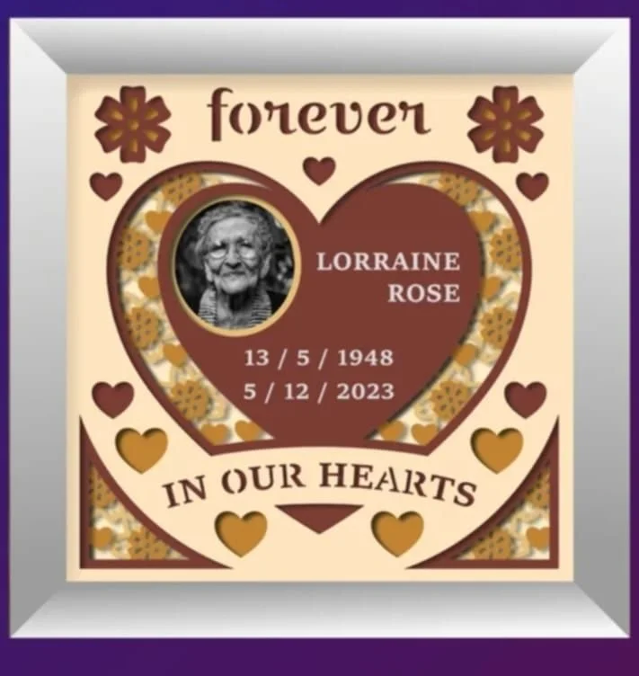Une image commémorative pour Lorraine Rose avec une photo d'une femme âgée, des coeurs et des fleurs, indiquant ses dates de naissance et de décès, et le message "Forever in our hearts".