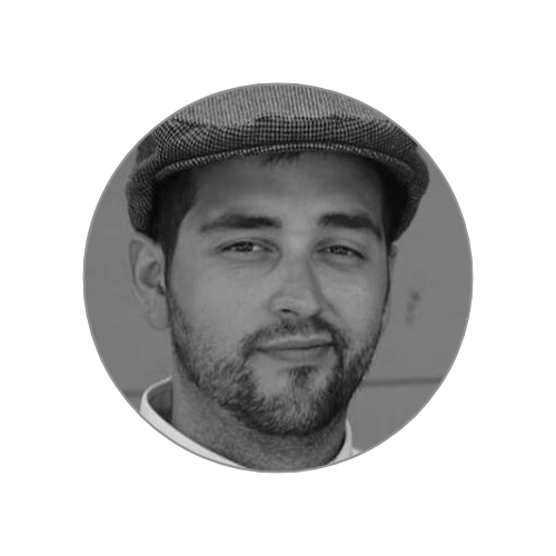 Black and white close-up of a man wearing a flat cap, looking at the camera with a slight smile.