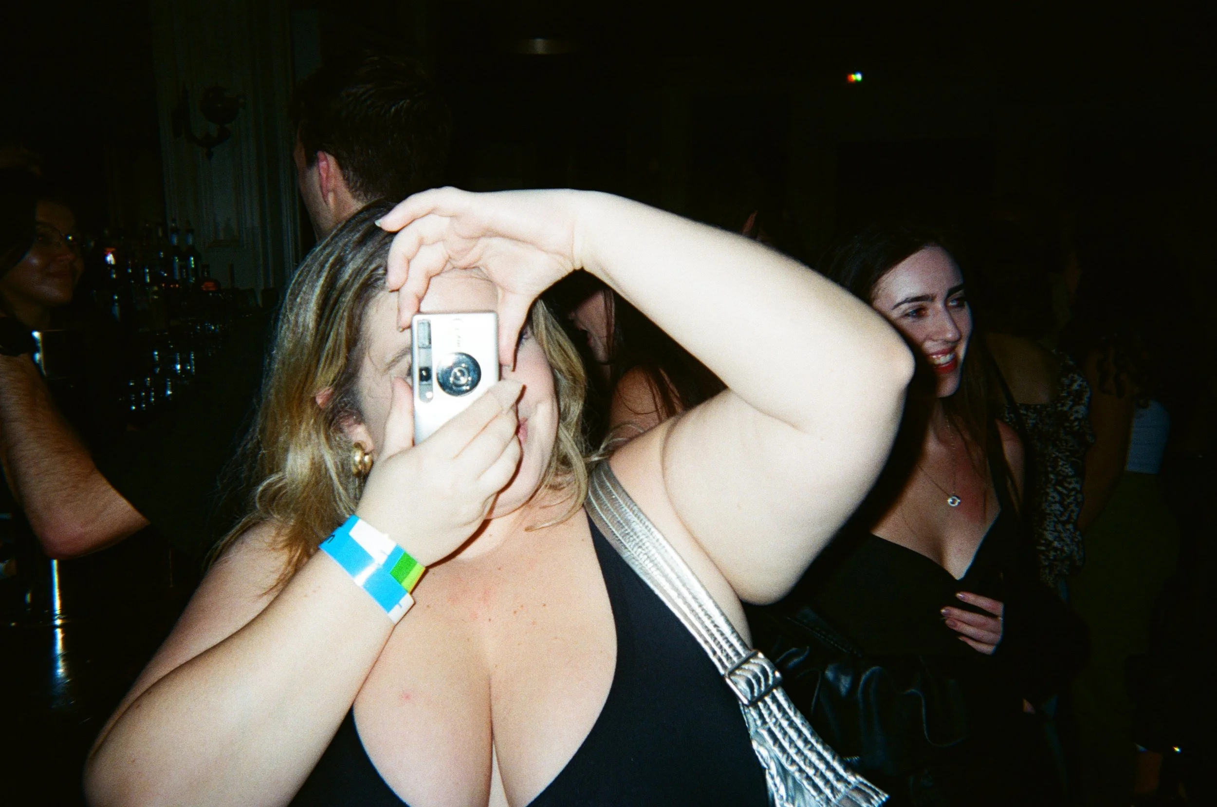 woman taking a picture on an old film camera highlighting her hyperfocused interest during her ADHD motivation