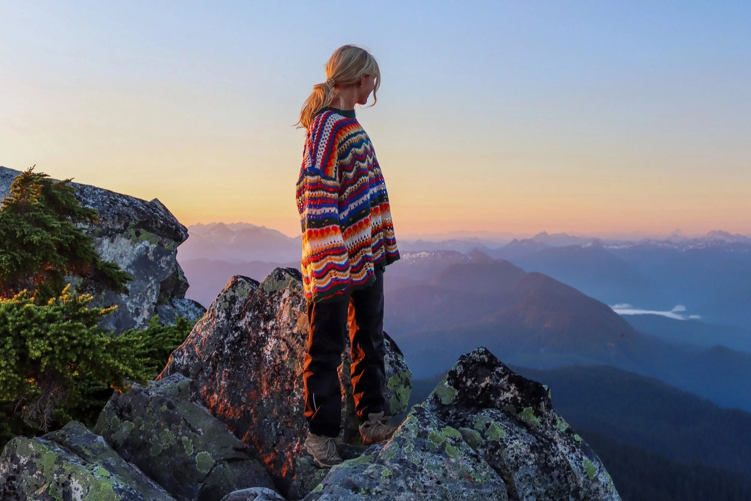 woman looking out over the rocky mountains and reminiscing over her childhood and the trauma it brought
