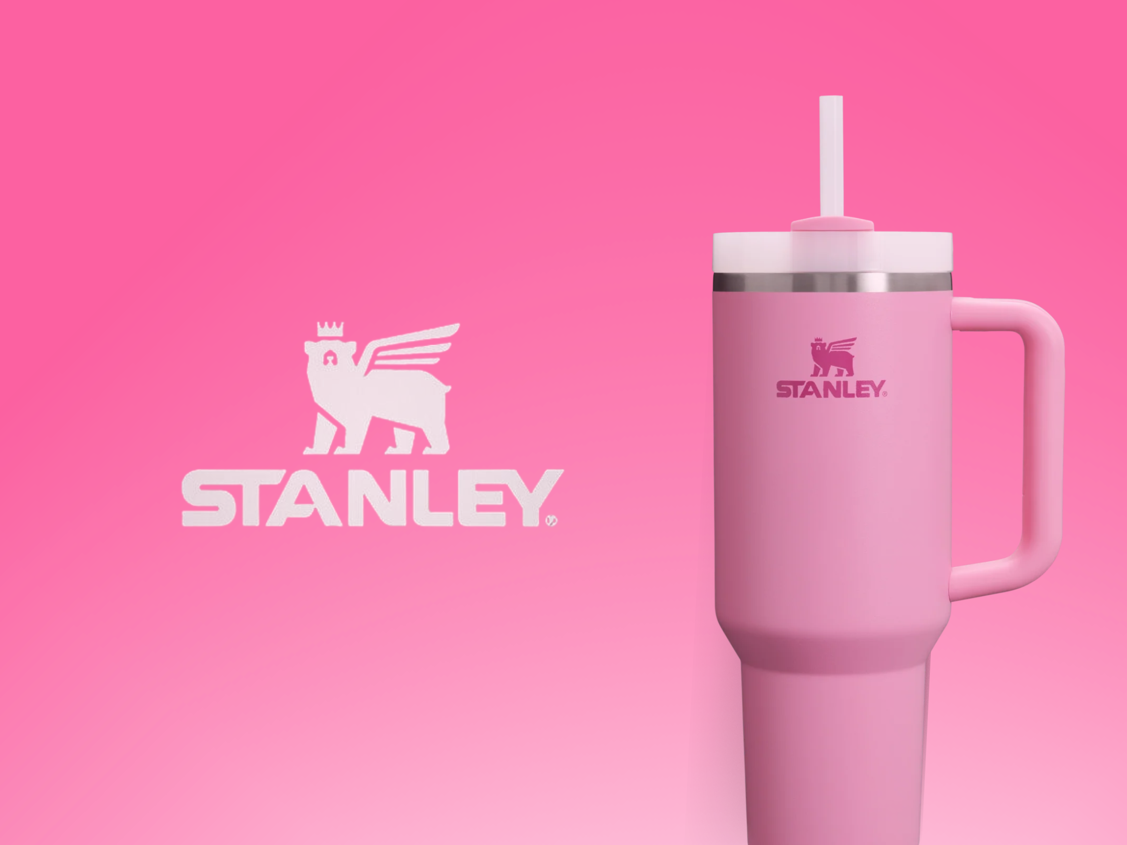 Pink Stanley reusable cup with straw and logo next to matching pink box with Stanley logo and royal lion emblem on a pink background.