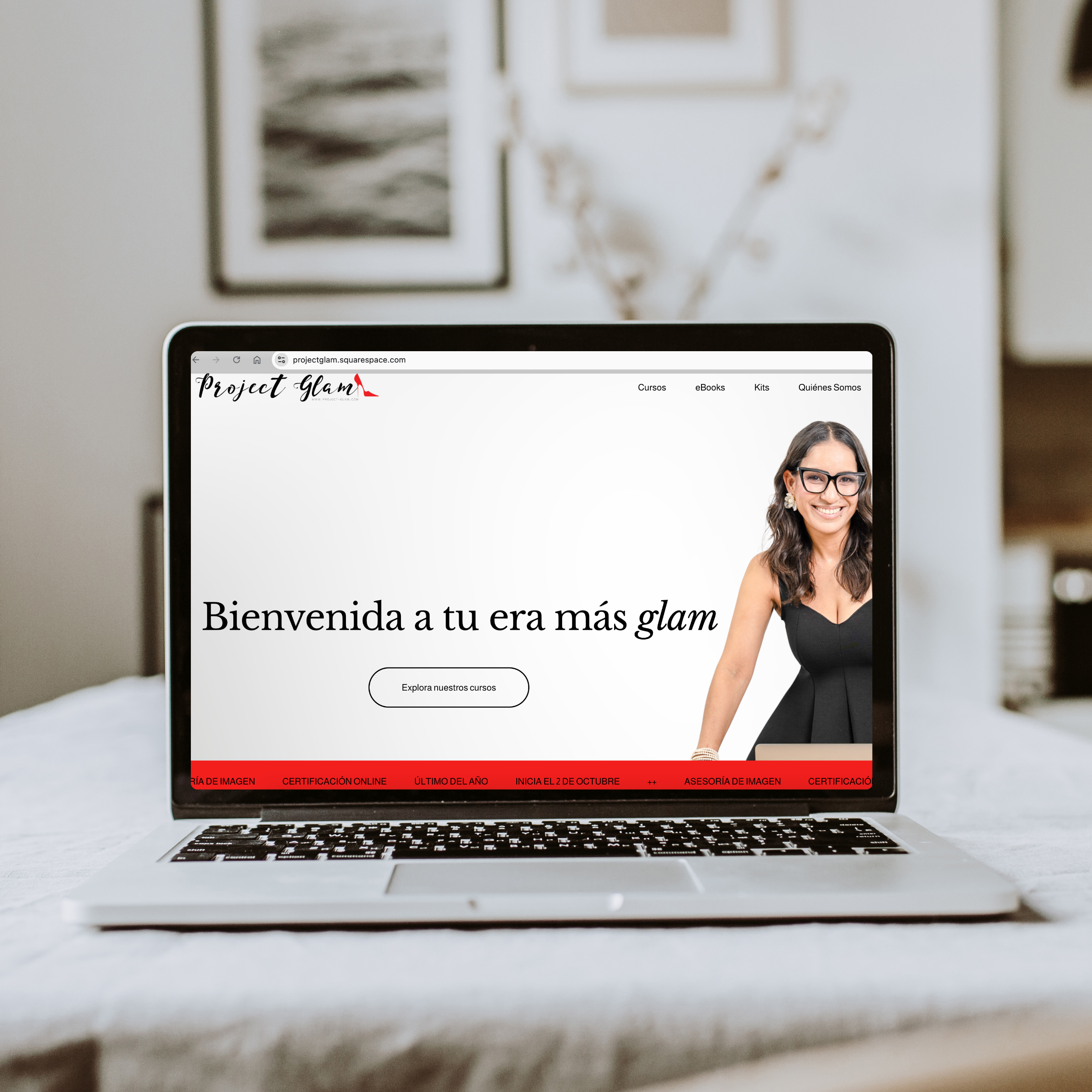 Pantalla de computadora portátil con sitio web de Project Glam, mostrando una mujer con gafas y vestido negro, en ambiente moderno