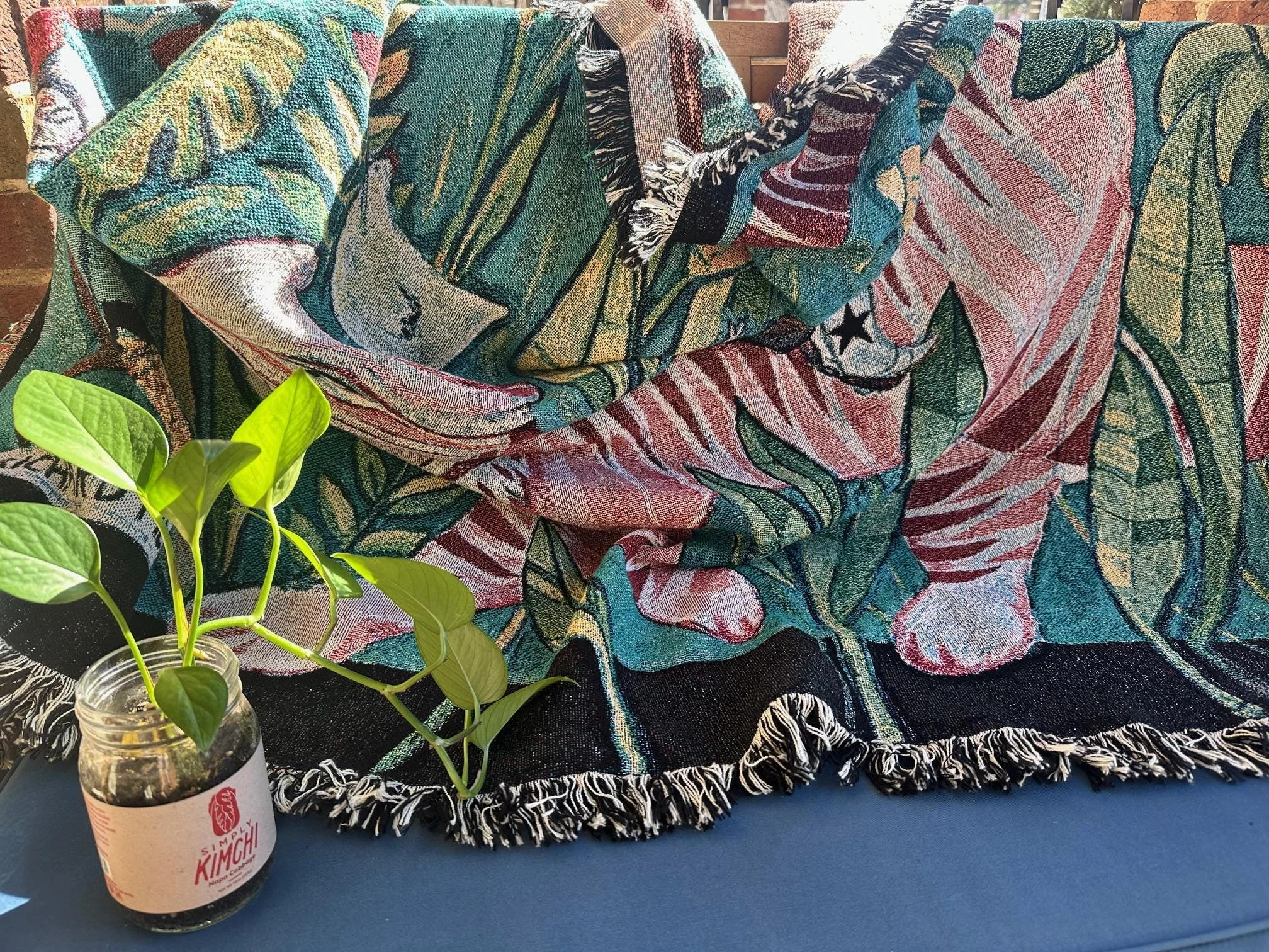 Large tapestry featuring a tiger, roommates, and plants in a vibrant painting.