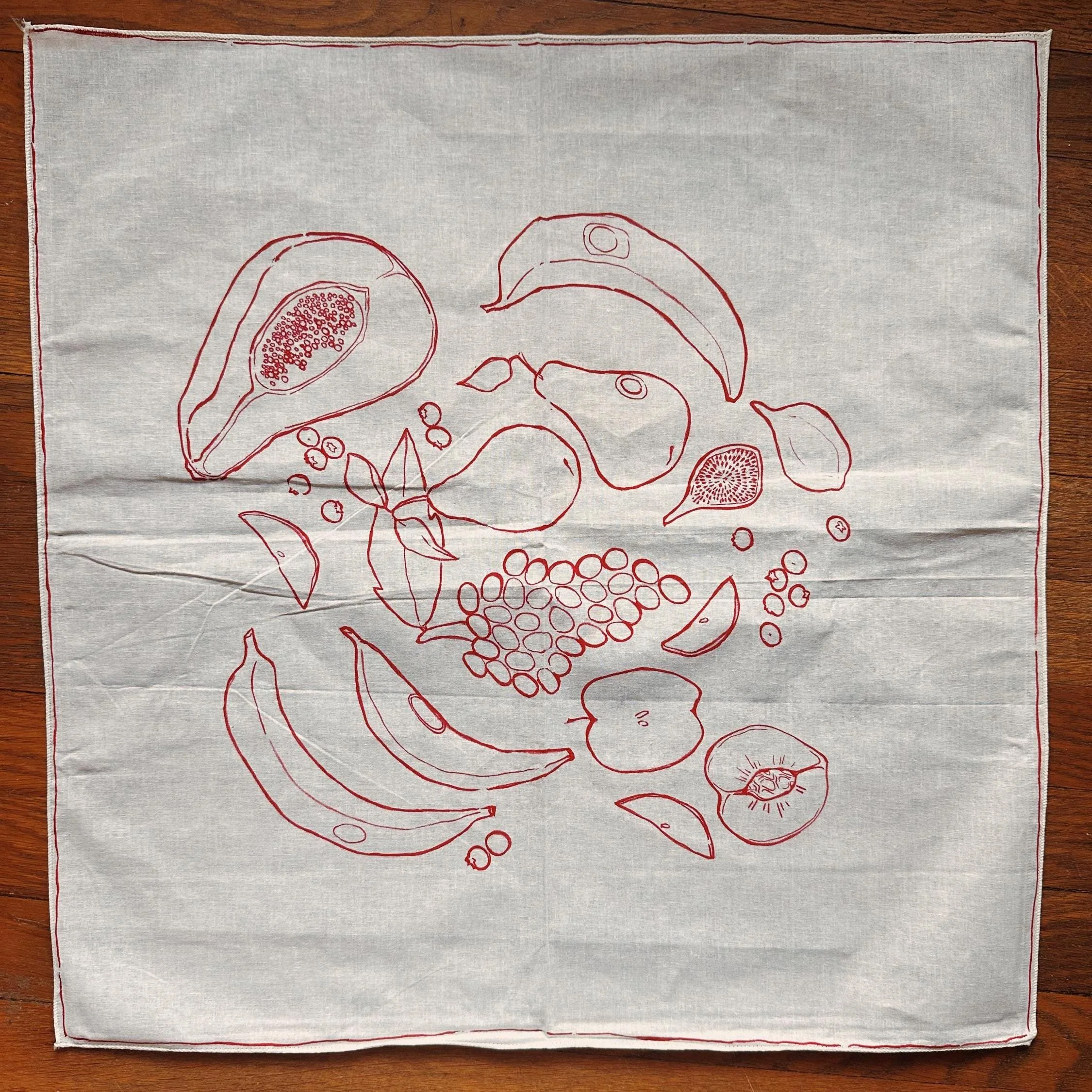 White hand-painted bandana with red fruit illustrations.