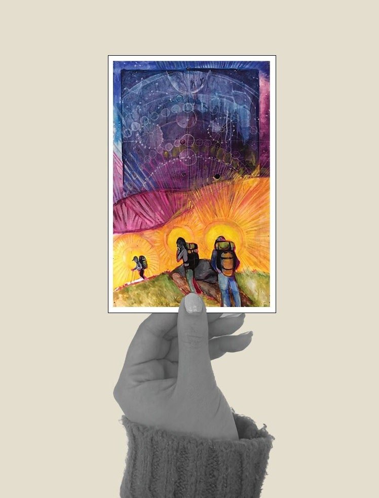 Art print of hikers standing before a galaxy sky and northern lights.